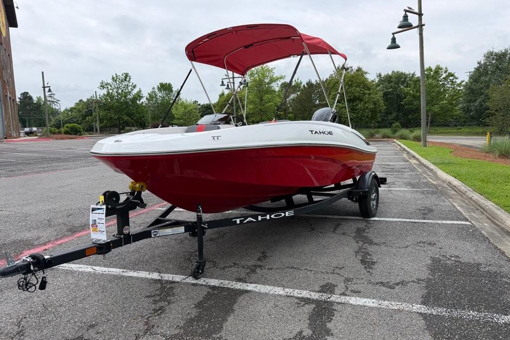 2026 Tahoe T16 boat with red hull and canopy on trailer in parking lot.