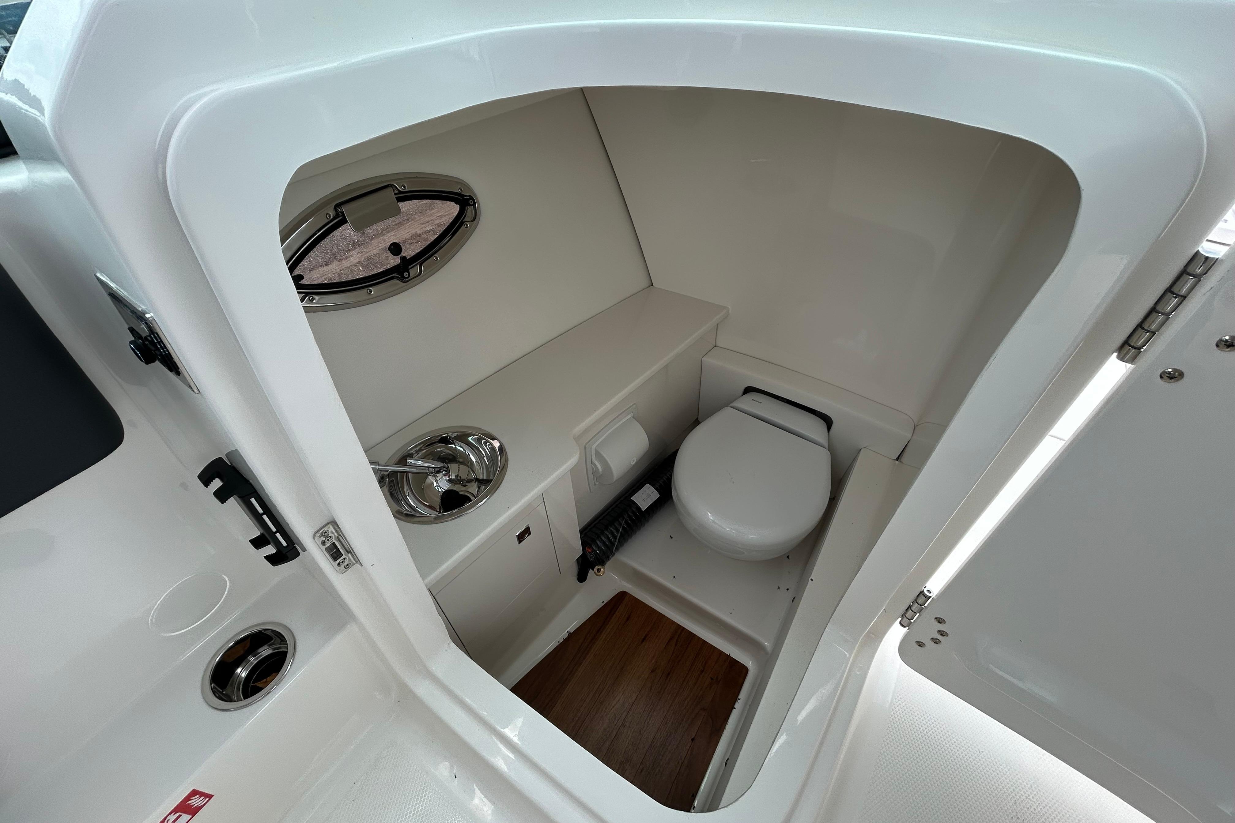 2026 Robalo R277 Dual Console boat interior with compact bathroom amenities.