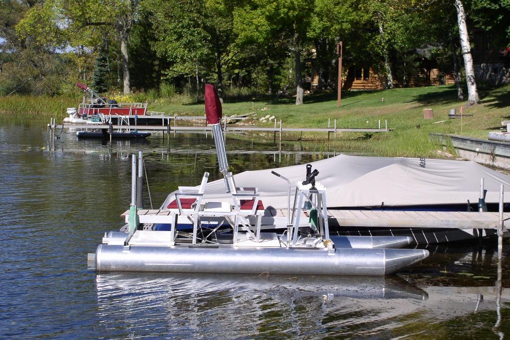 Aqua Cycle 2 pontoon boat docked on a serene lake, surrounded by lush greenery.