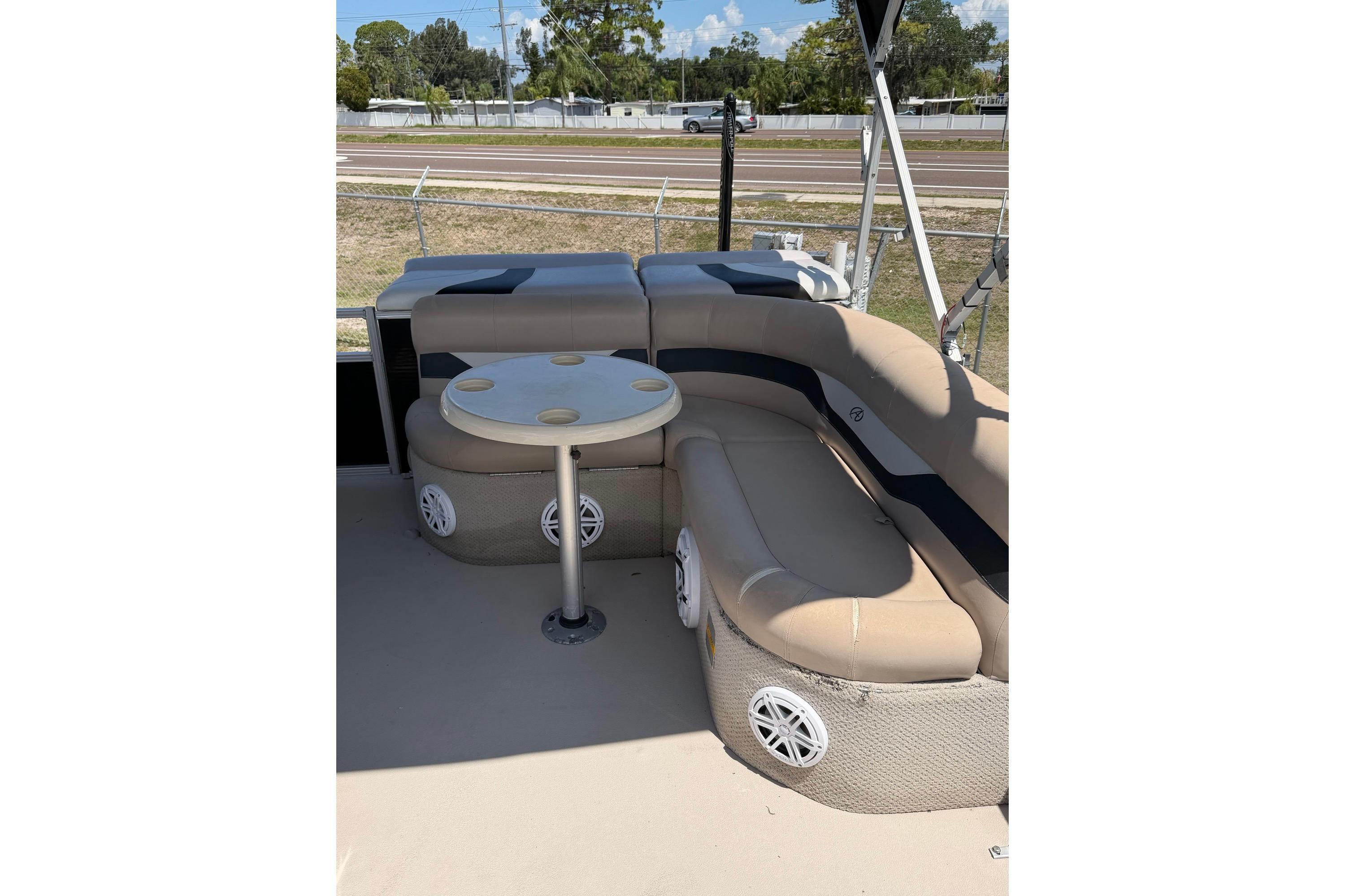2014 Avalon 1900 boat interior with beige seating and round table.