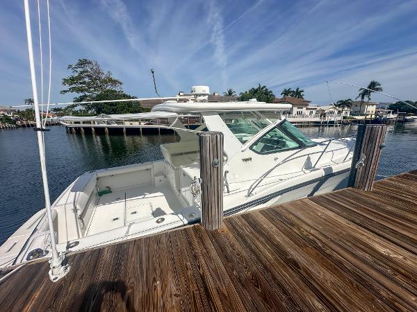 2006 Tiara Yachts 3200 Open docked by a wooden pier under a clear sky.