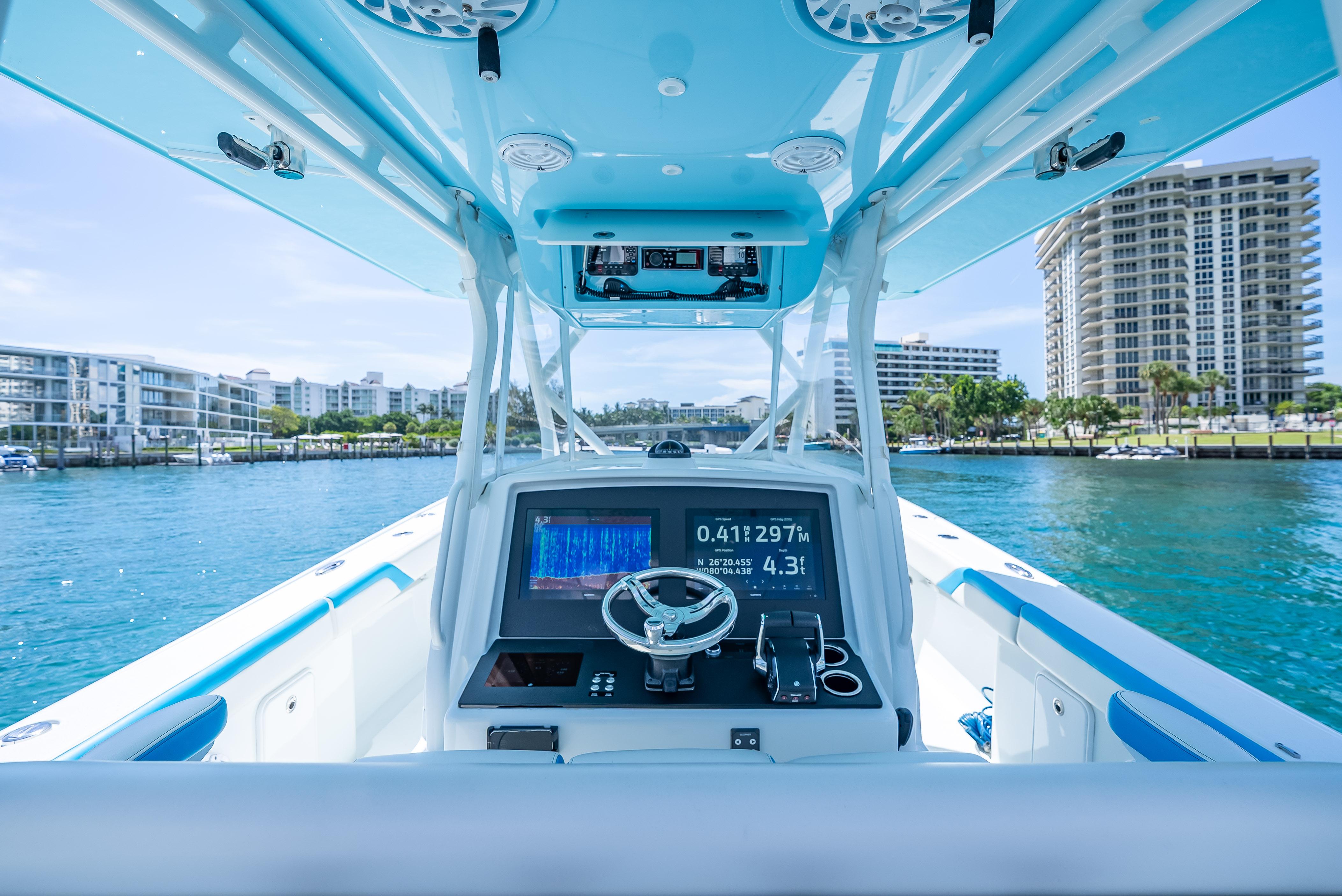 2016 Yellowfin 39 Offshore boat dashboard with navigation system, cruising in a coastal cityscape.