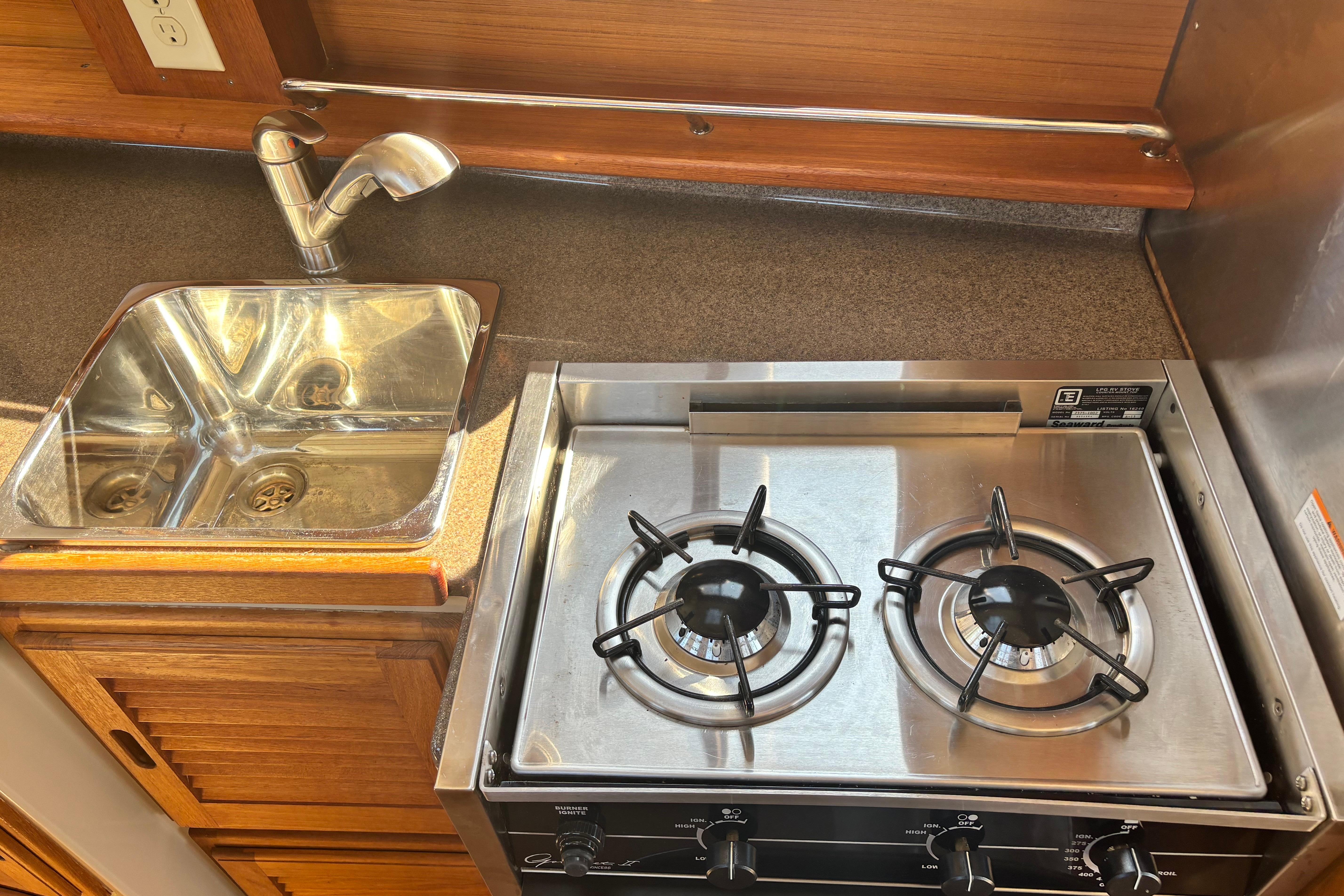Compact kitchen in 2015 Ranger Tugs R-27 with stove and sink.