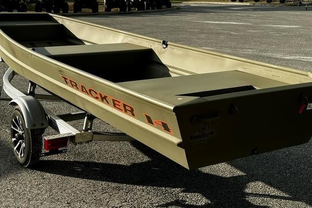 2026 Tracker Grizzly 14 Jon boat on trailer, parked on asphalt.