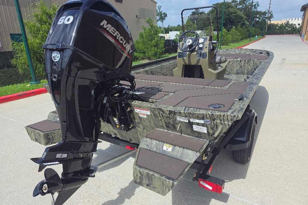 2026 Tracker Grizzly 1860 CC boat with Mercury engine, parked outdoors on a sunny day.