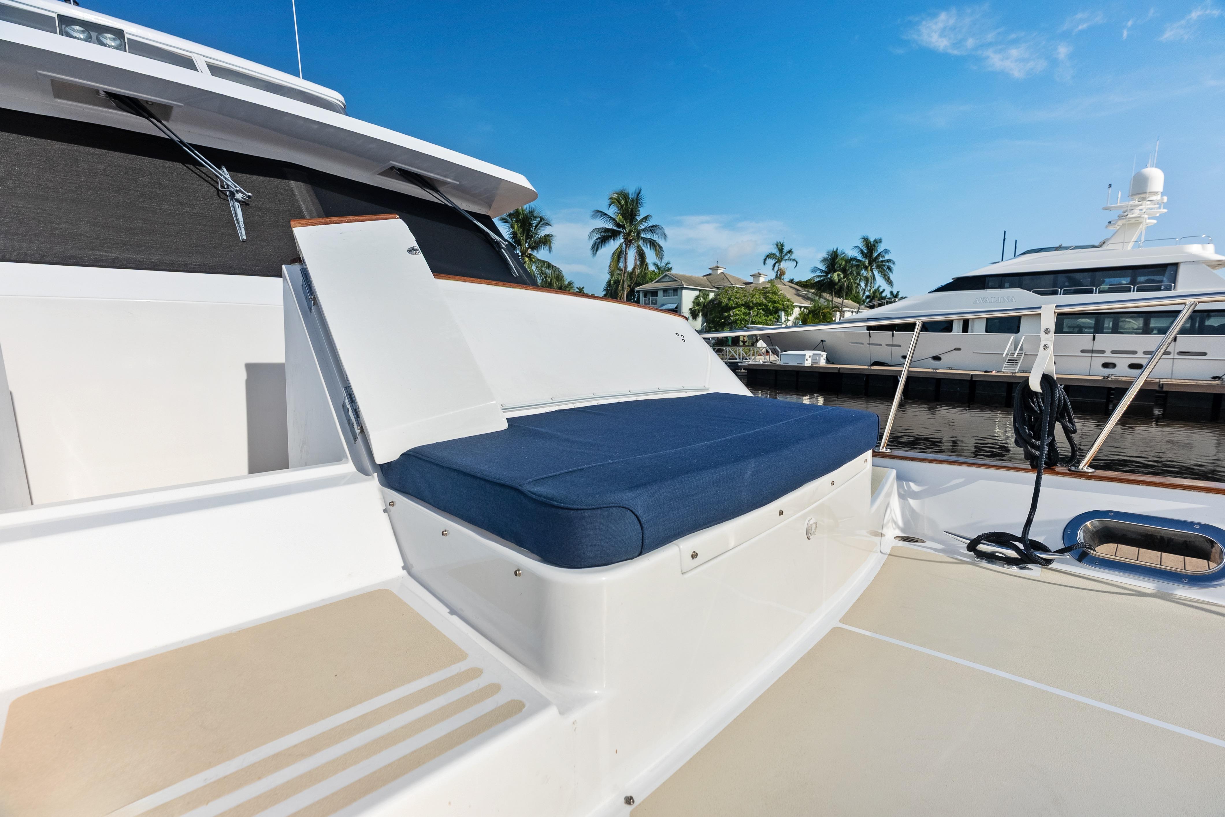 2005 Grand Banks 72 Aleutian RP yacht deck with blue cushioned seating, docked near palm trees.