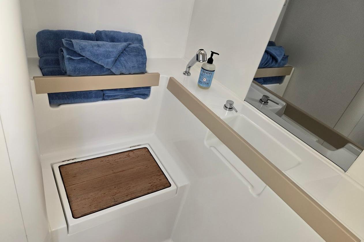 Bathroom interior of 2023 Beneteau Oceanis 38.1 yacht with towels and soap.