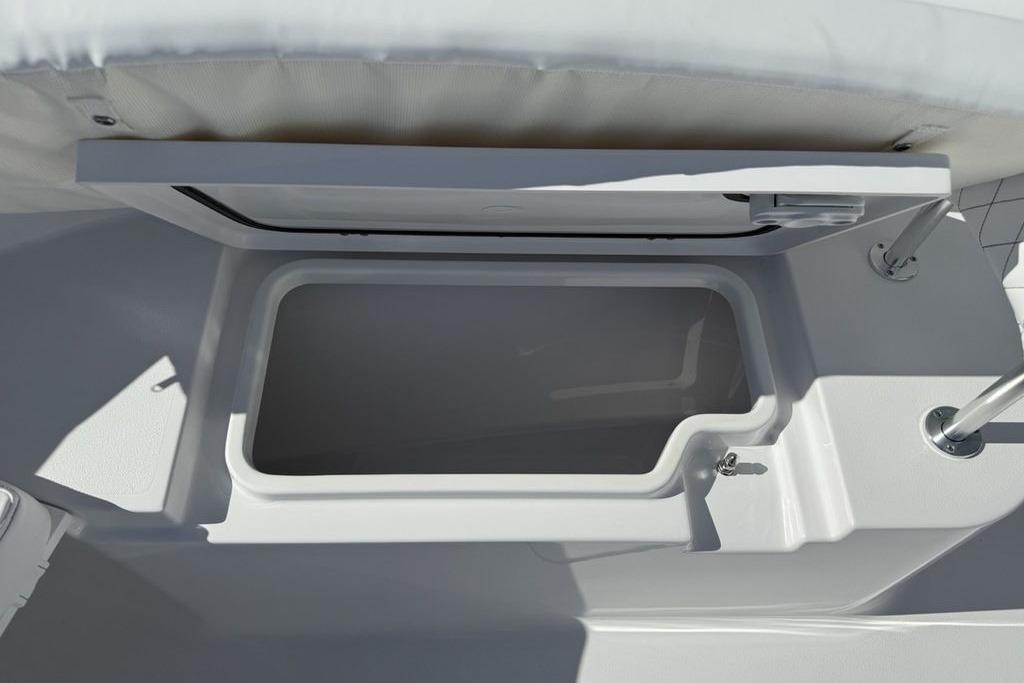 2026 Sportsman Open 232 Center Console storage compartment, open lid, white interior.
