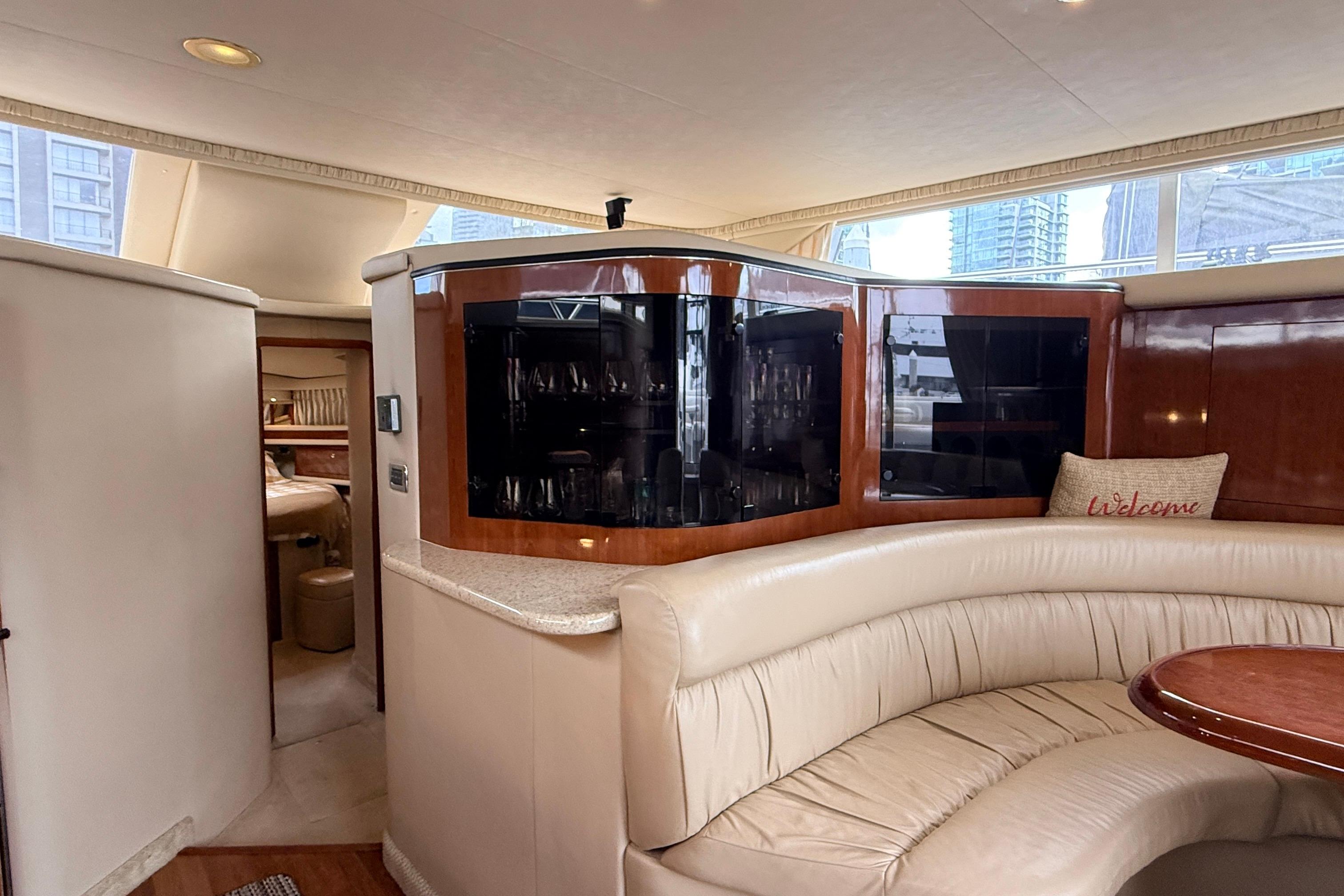 Luxurious interior of 2003 Sea Ray 450 Express Bridge yacht with elegant seating and cabinetry.