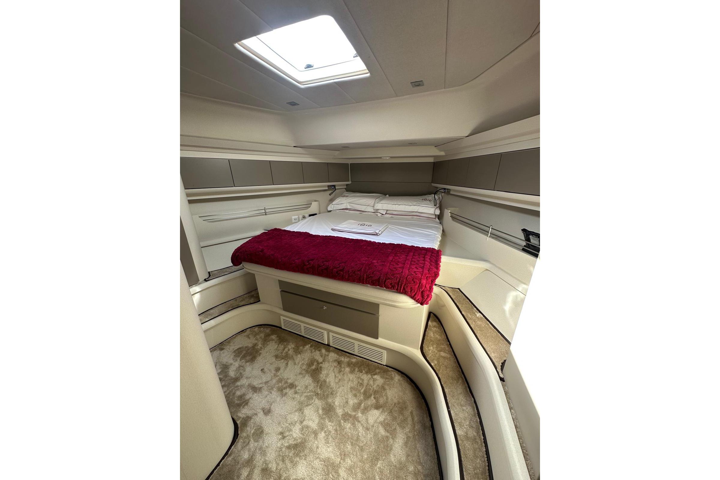 Luxurious cabin interior of 2005 Mochi Dolphin 51 yacht with plush bedding and skylight.