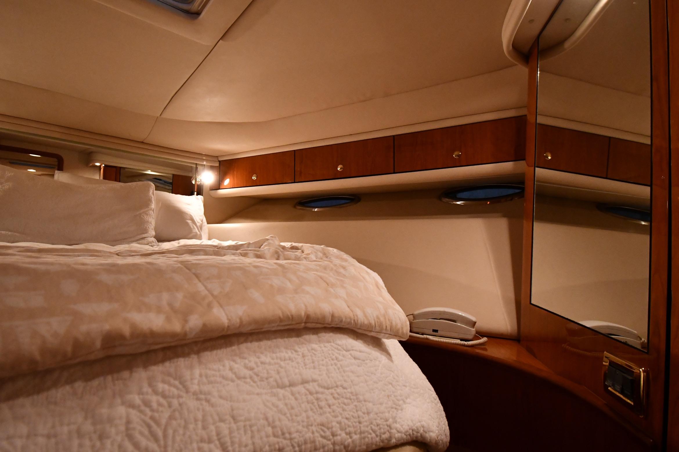 Luxurious cabin interior of 2001 Sea Ray 540 Sundancer yacht with cozy bedding.