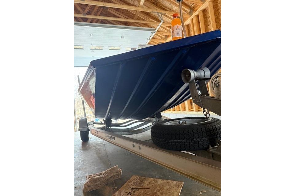 2018 Alumacraft Pro 185 boat on trailer in garage, viewed from below.