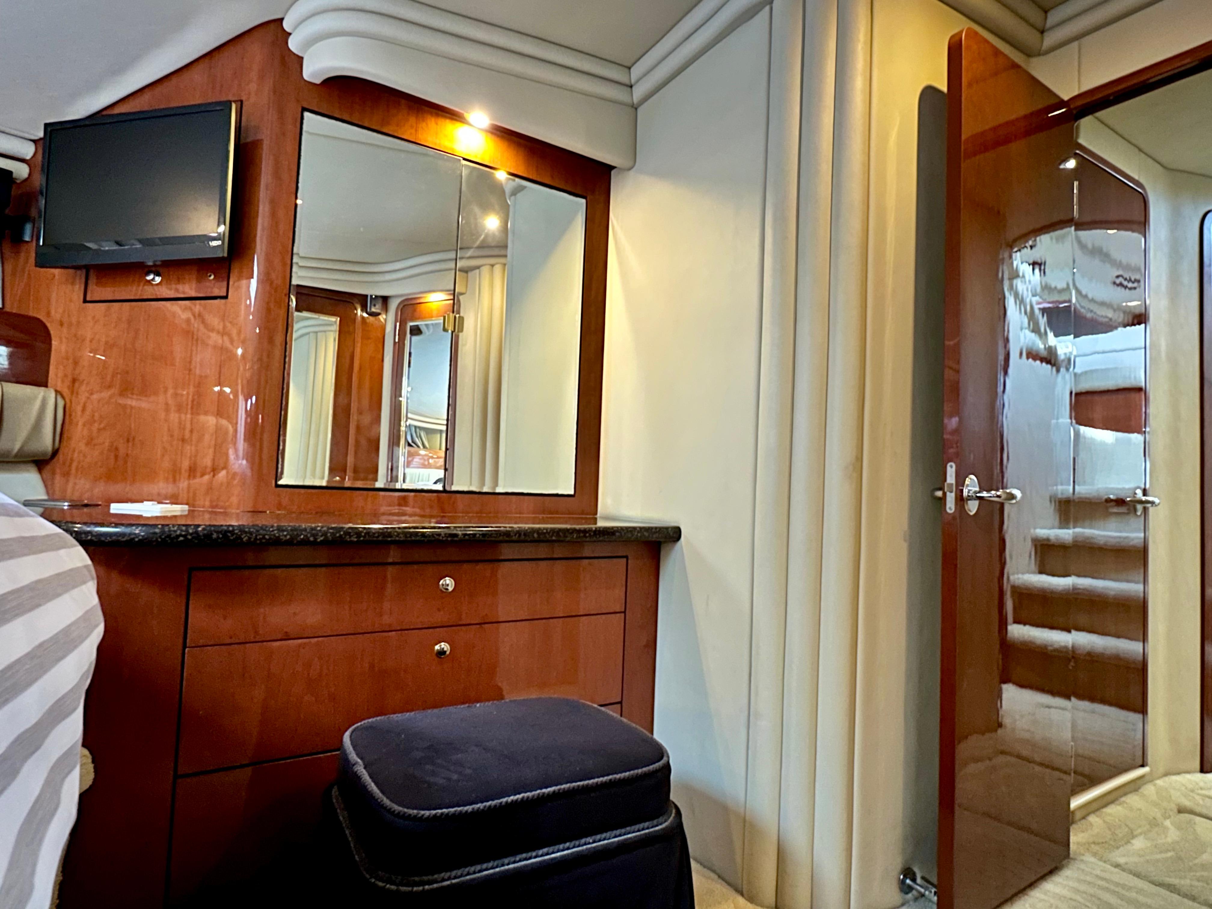 Luxurious interior of 2002 Sea Ray 560 Sedan Bridge with wood cabinetry and mirror.