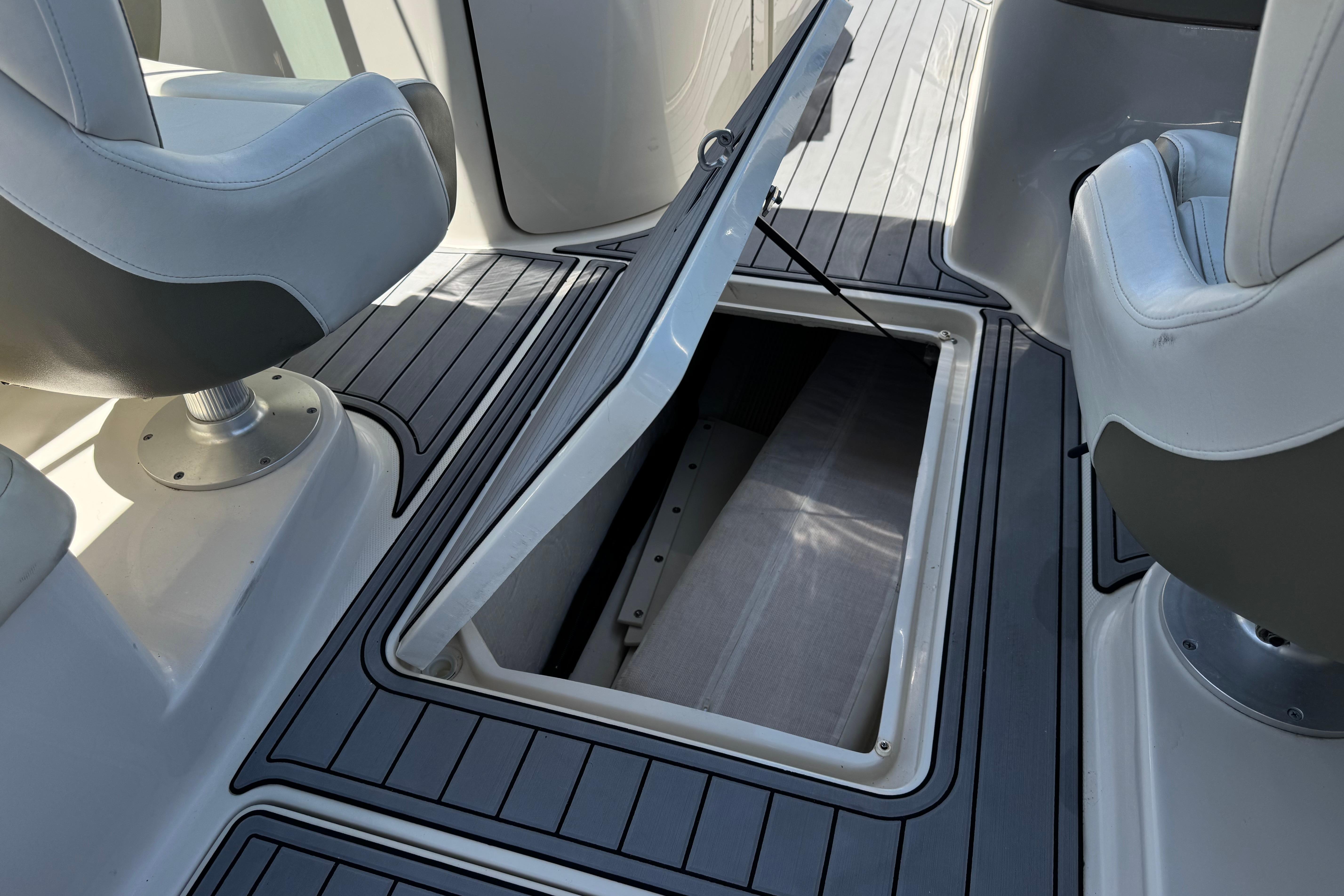 2007 Sea Ray 240 Sundeck interior with open storage compartment and seating.
