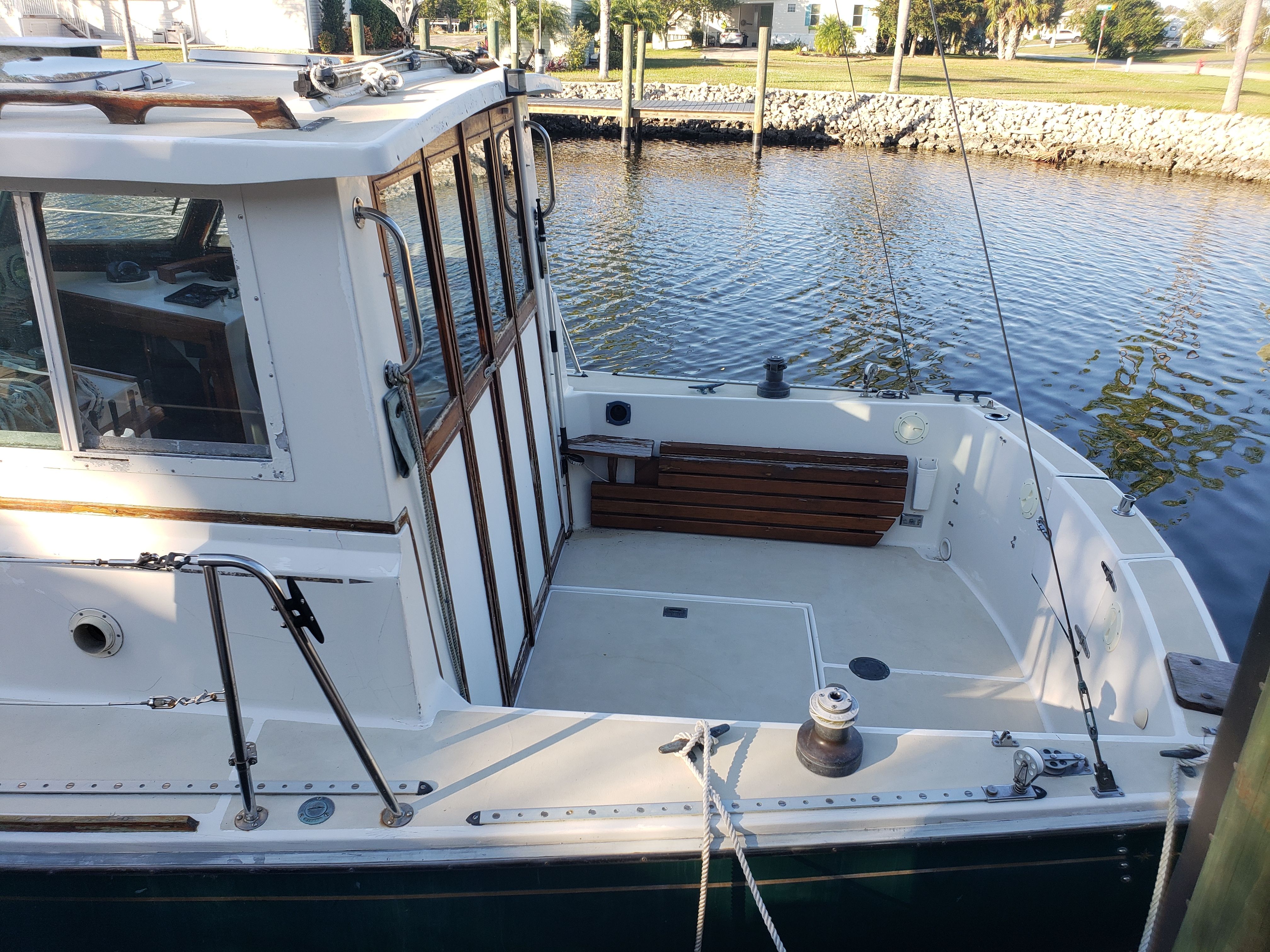 The image shows a 1989 Cape Dory MS300 boat docked at a calm waterfront.