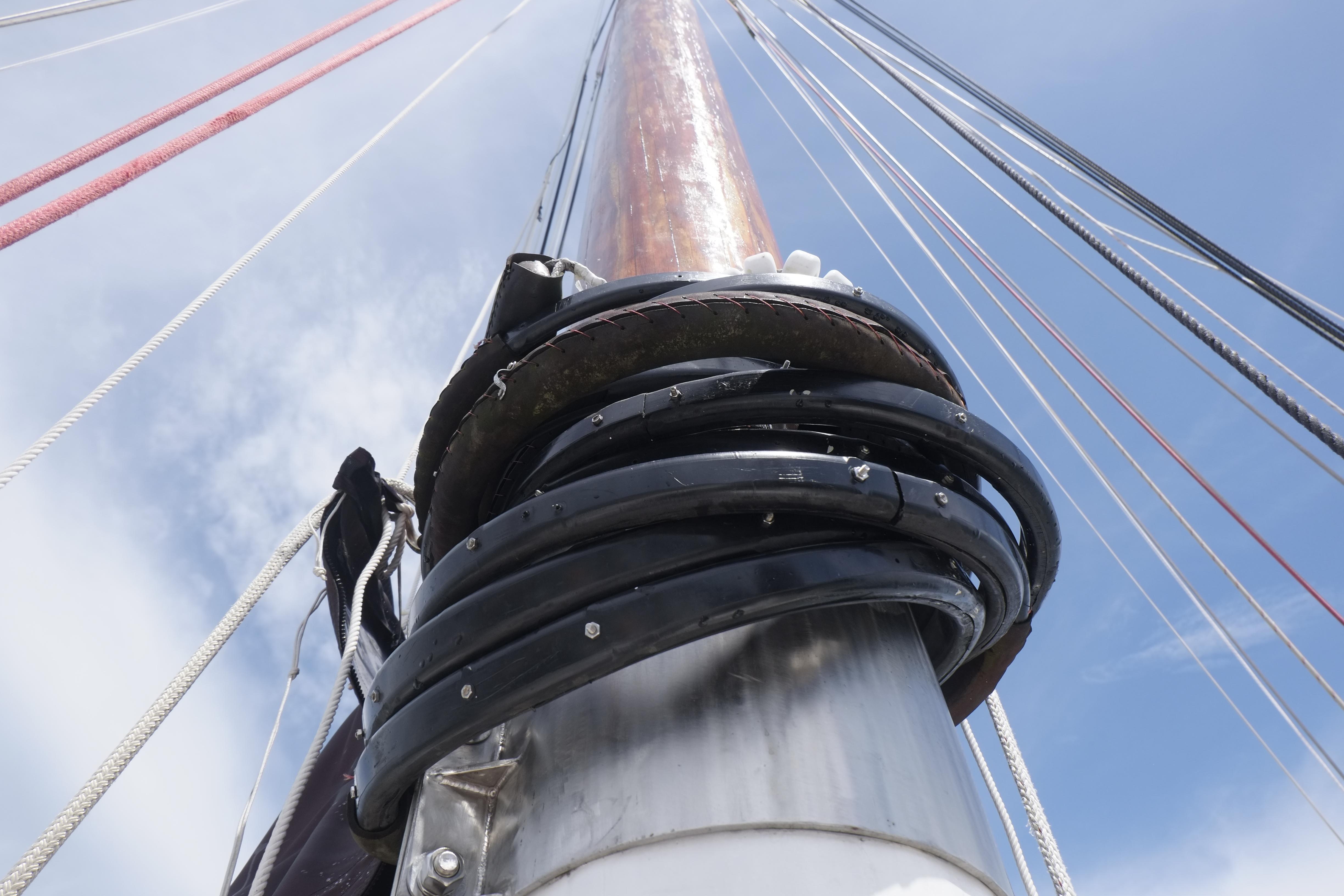 Close-up of a 2006 Custom Bud Macintosh schooner mast with rigging against blue sky.