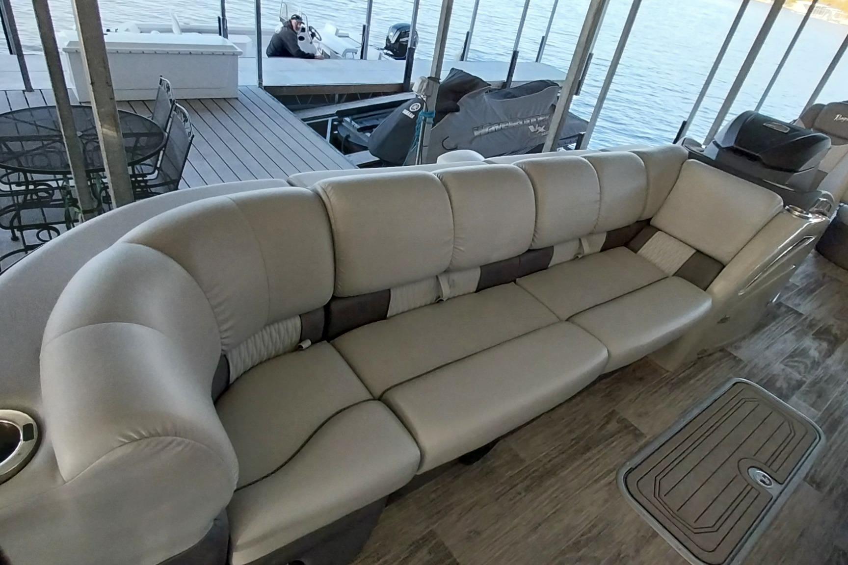 Luxurious seating on 2023 Ranger 2500LS pontoon boat, docked by the water.