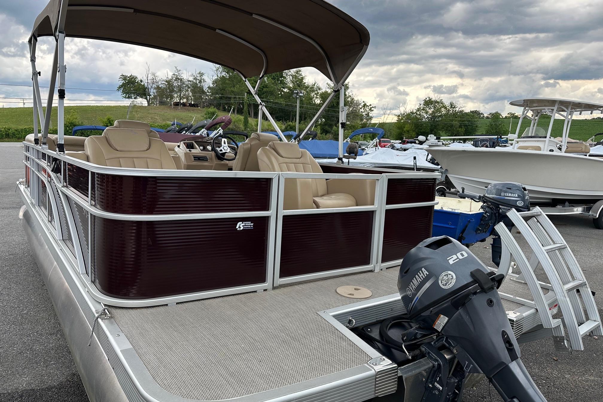 2016 Bennington 24 SCWX pontoon boat with Yamaha 20 outboard motor, parked outdoors.