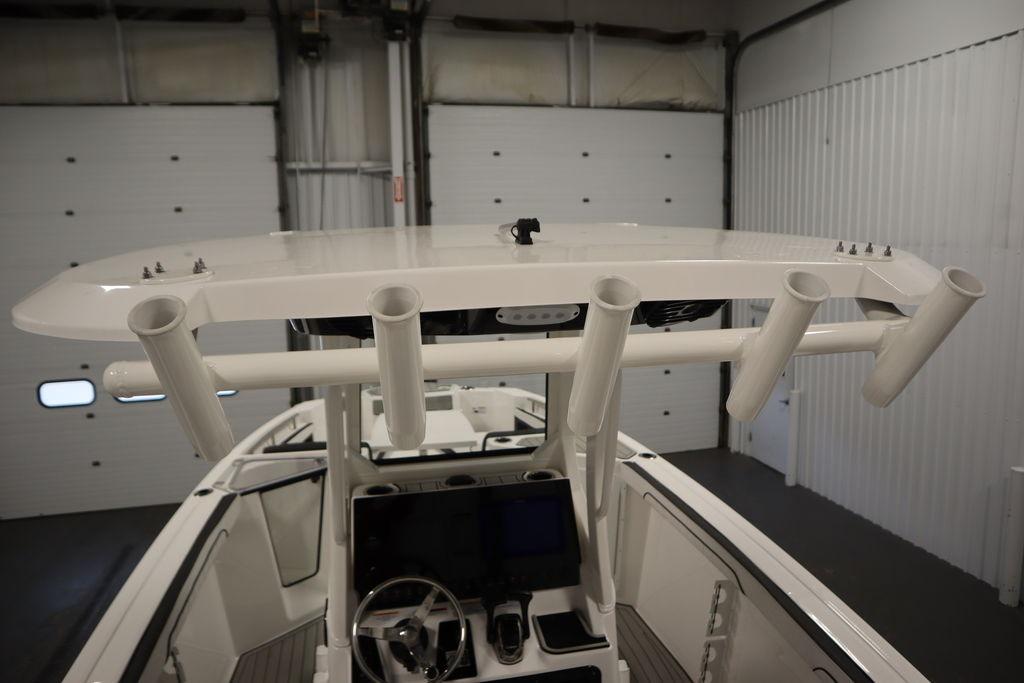 2026 Yamaha Boats 255 FSH Sport E, interior view with rod holders and steering console.