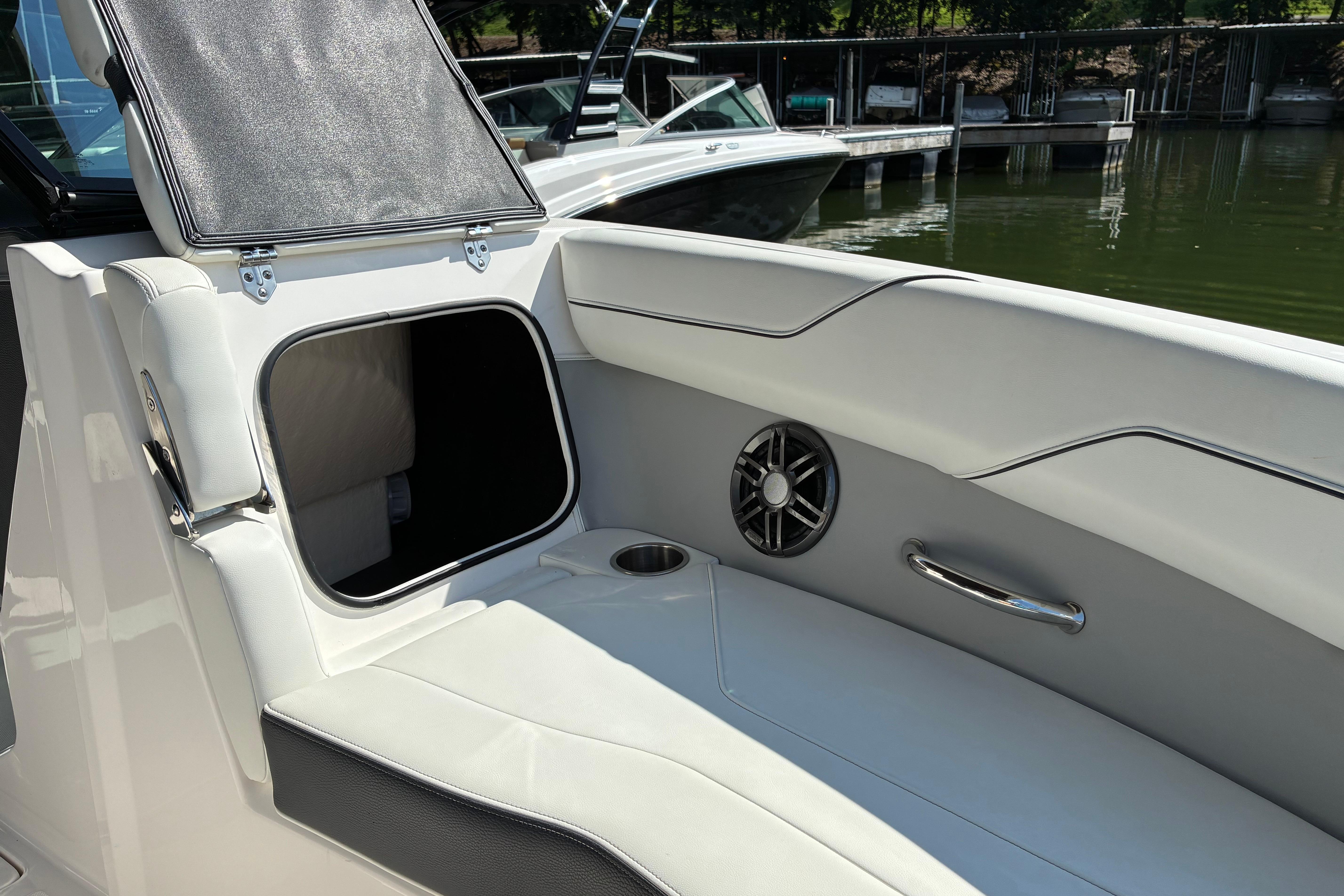 2025 Regal LS2 boat interior with storage compartment and speaker, docked by the water.