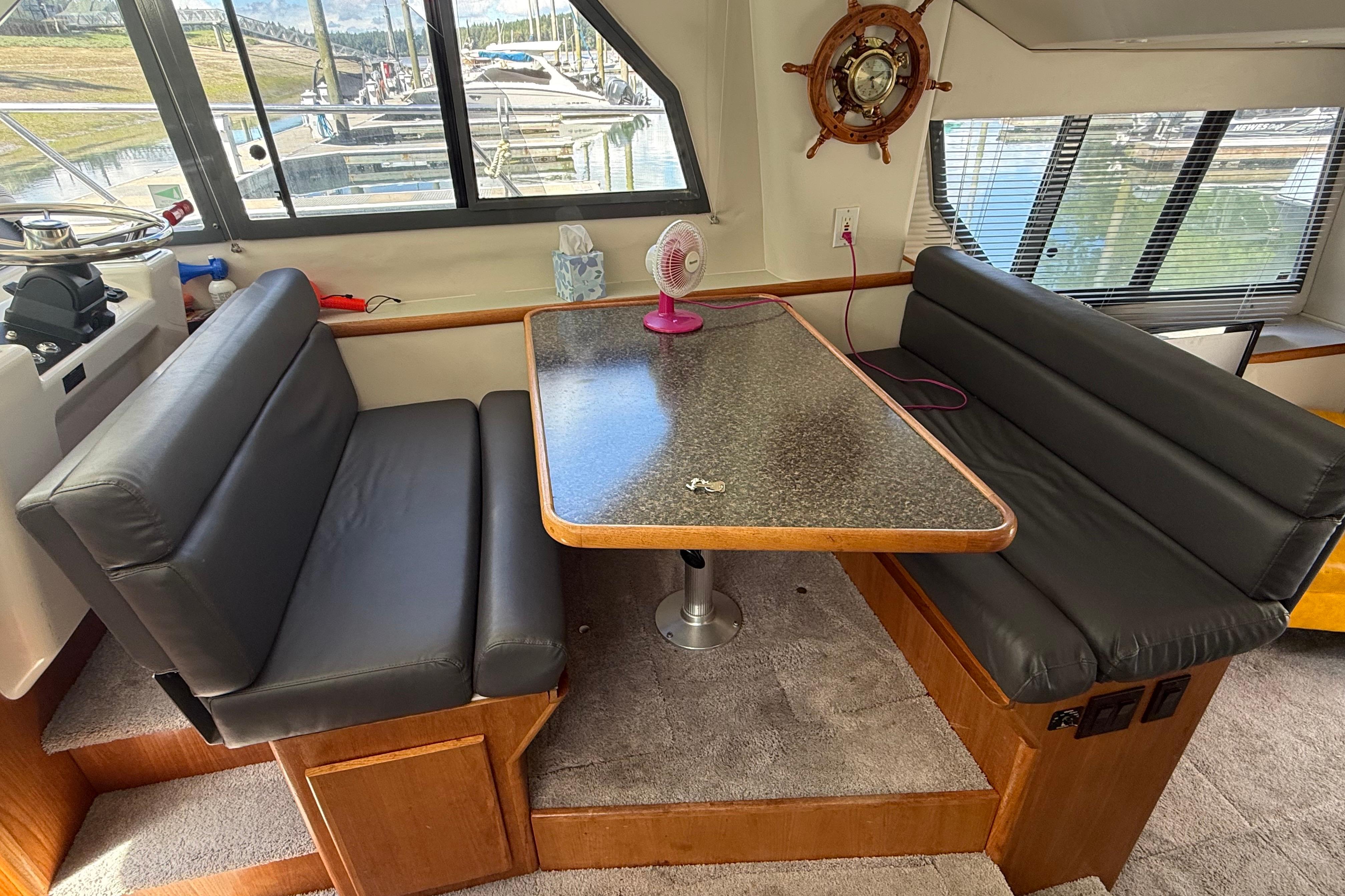 Interior of a 1995 Carver 370 Voyager with a dining area and nautical decor.