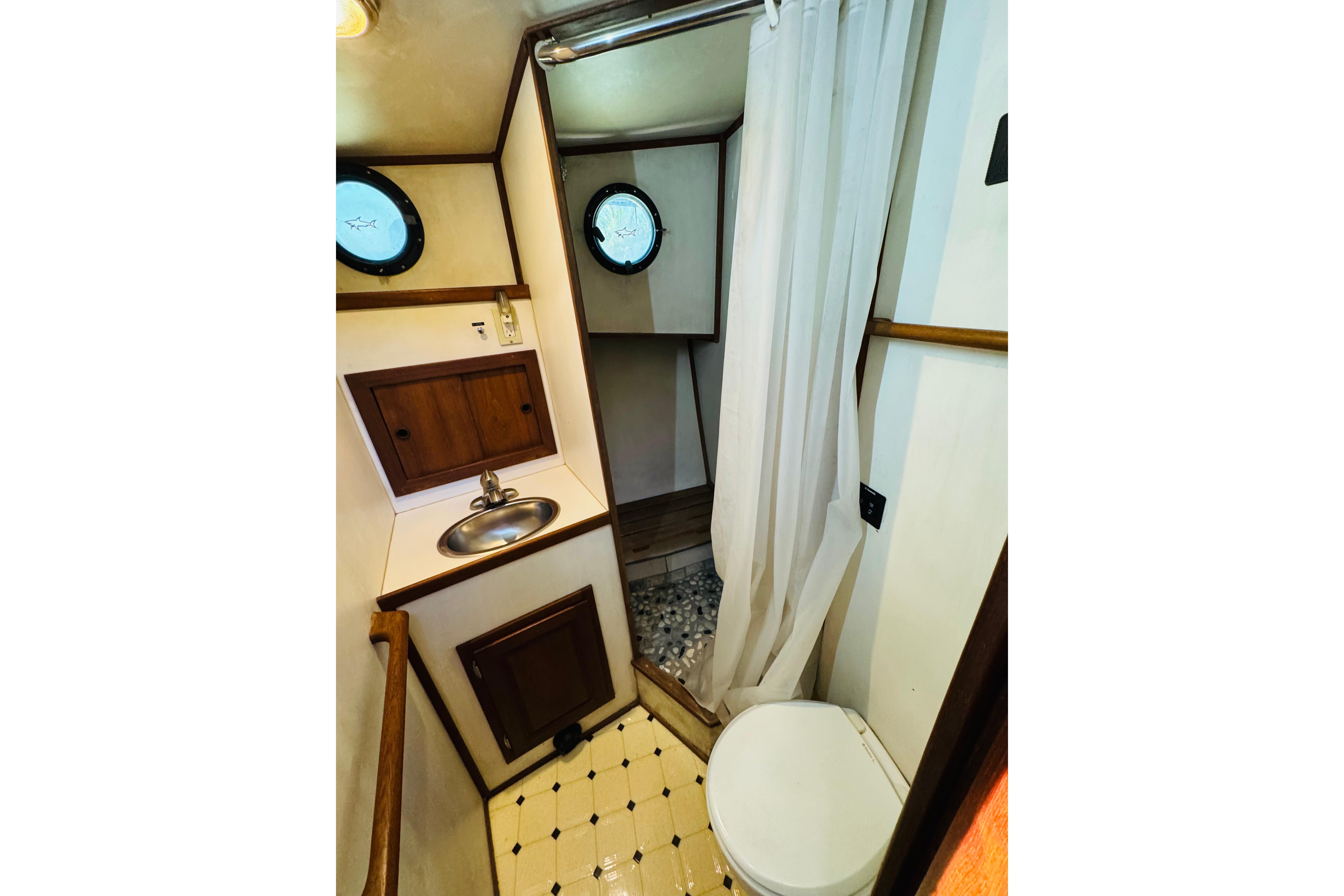 Bathroom interior of 1996 Nordic Tug 32 with sink, toilet, and shower curtain.