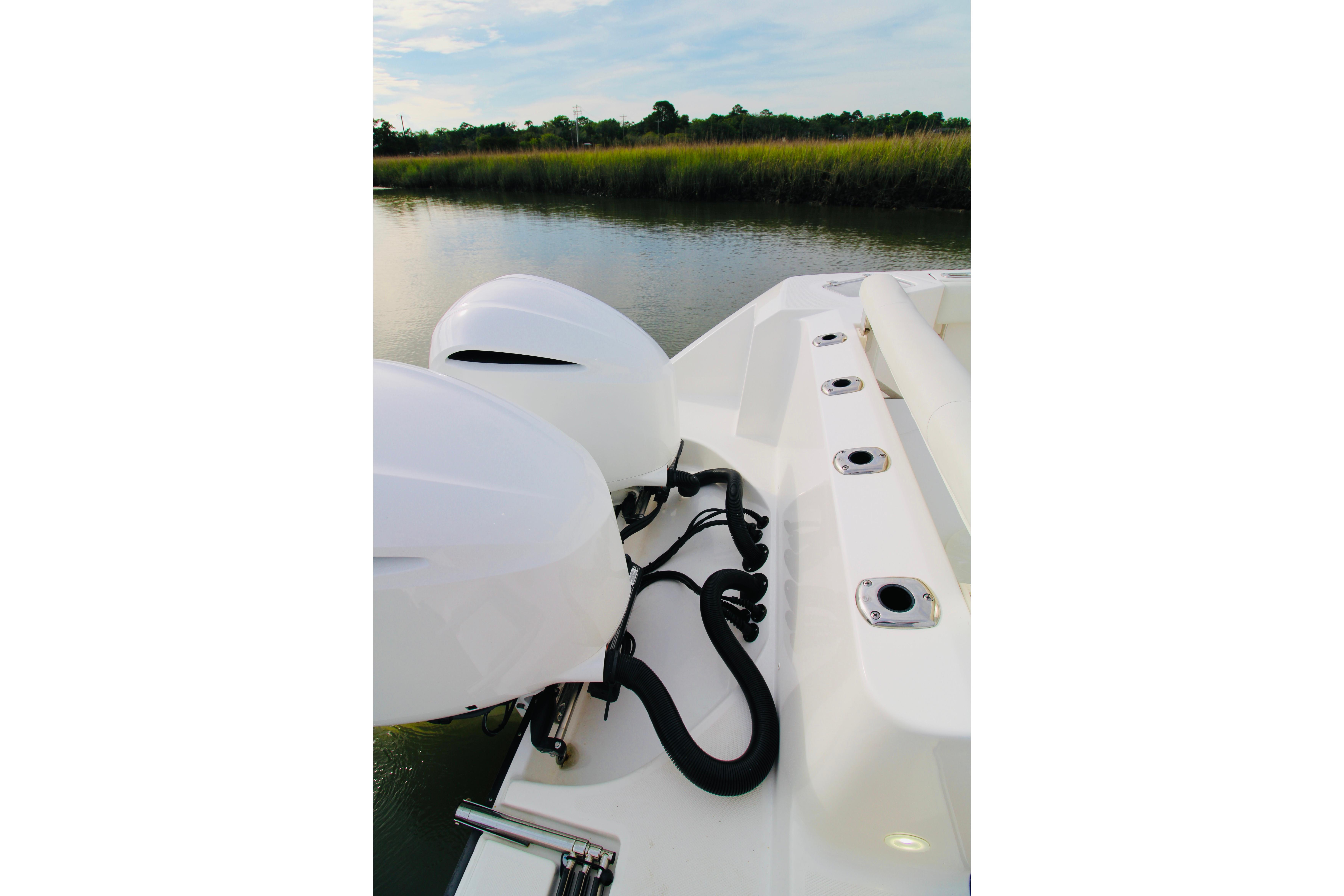 Edgewater 280CC 2022 boat with dual engines on a calm river.