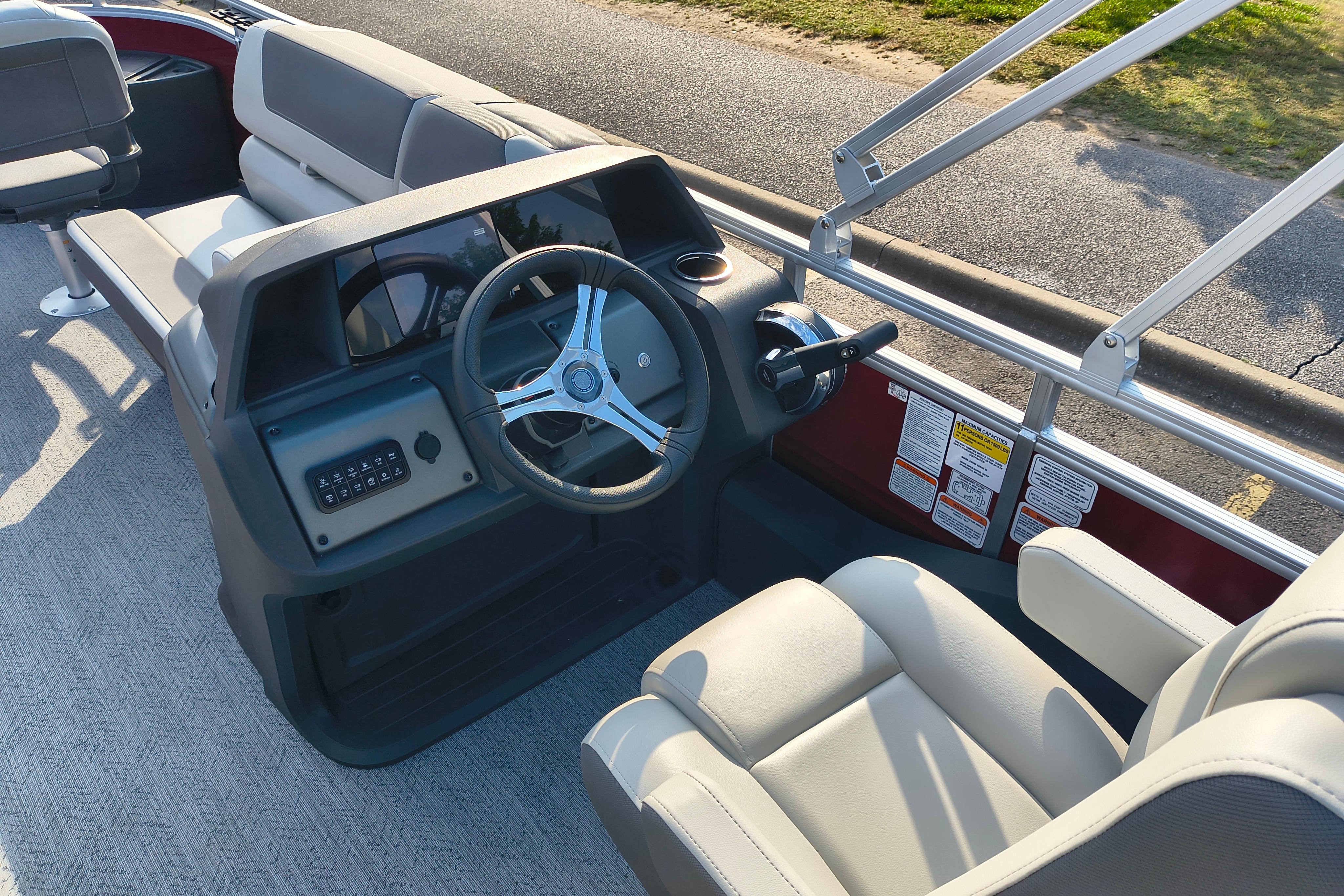 2026 Sun Tracker Fishin' Barge 22 DLX interior with steering wheel and seating.