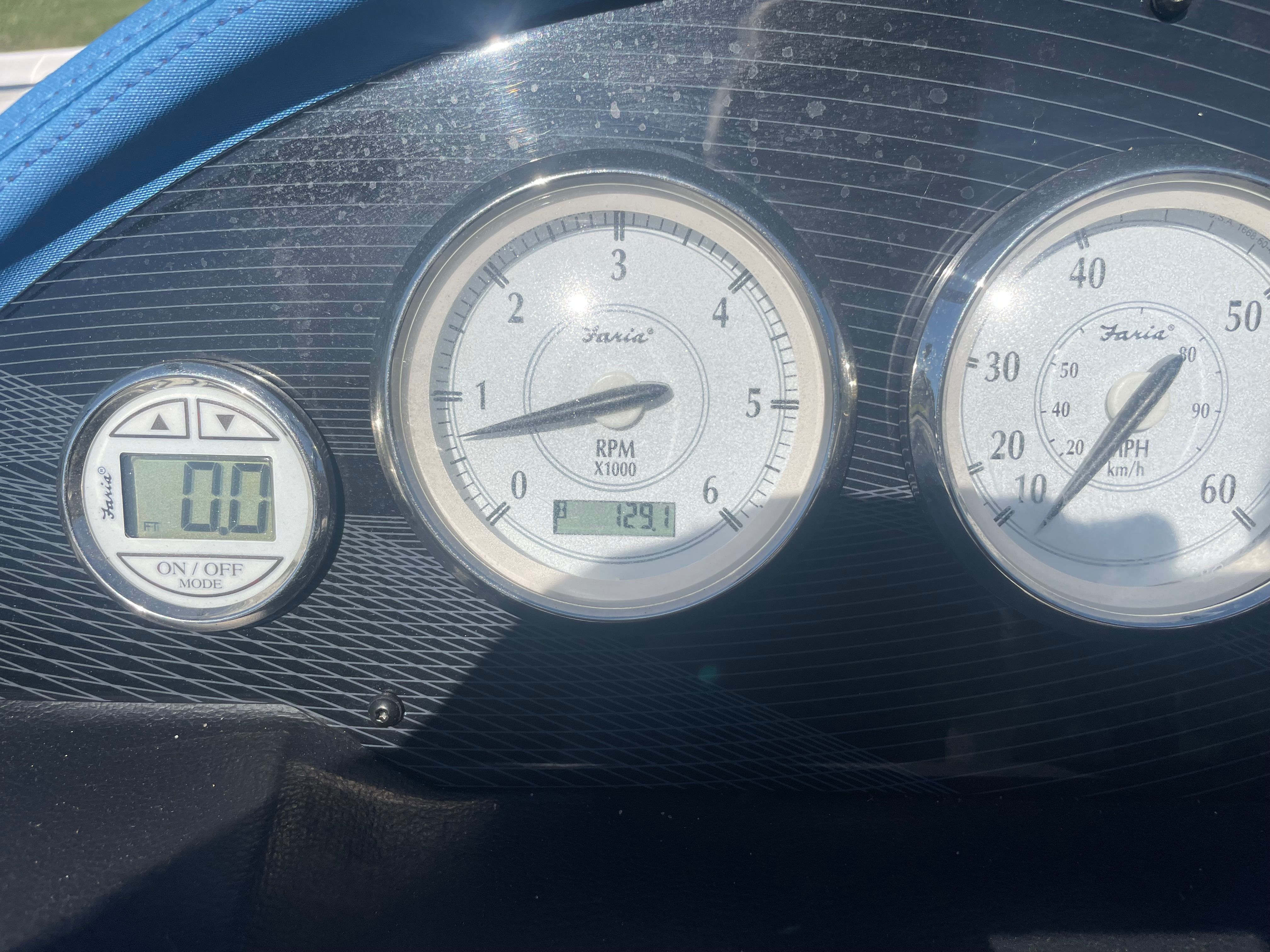 Close-up of a boat dashboard with three gauges.