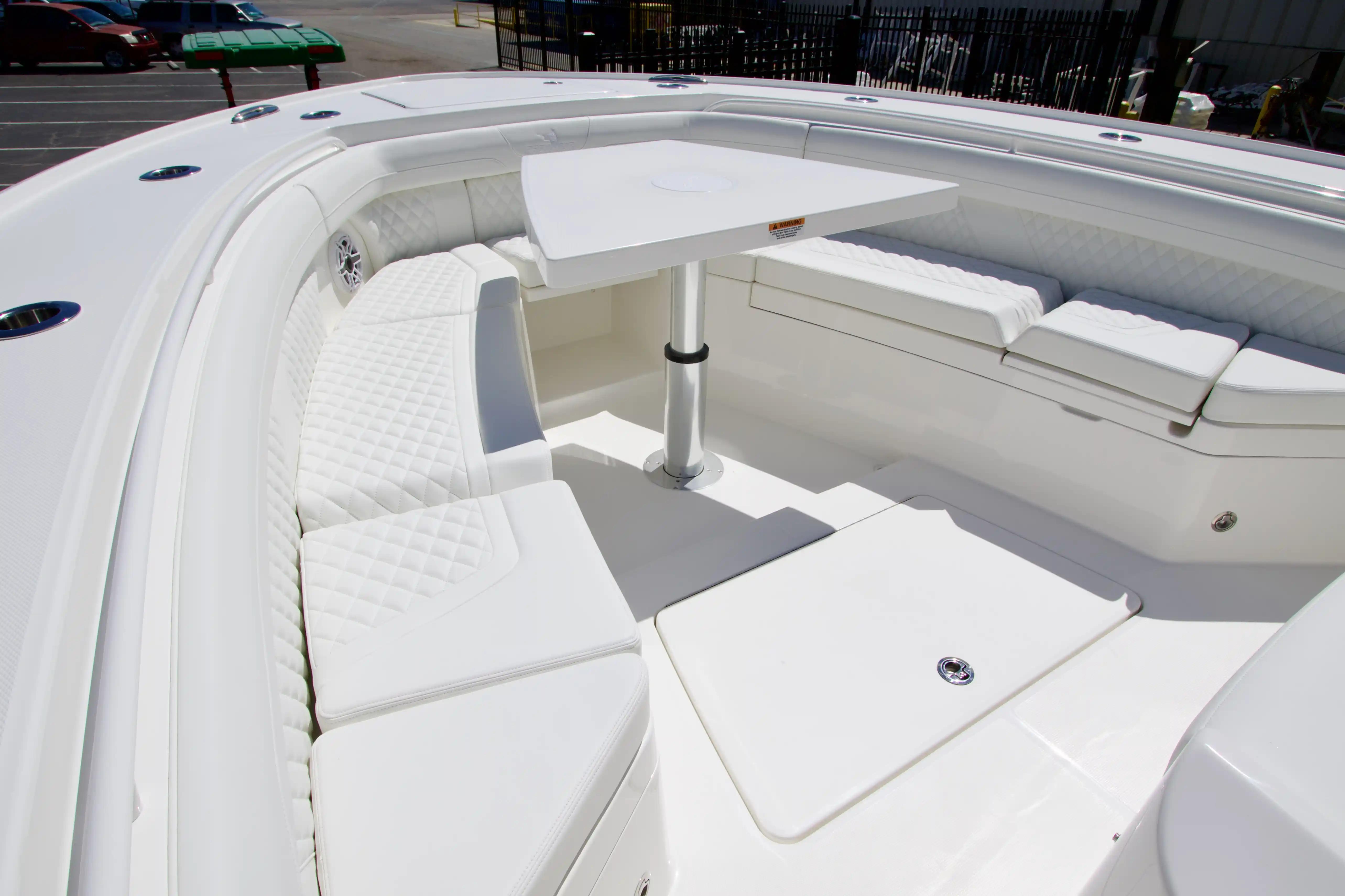 Luxurious seating area on a 2027 Regulator 35 boat, featuring white upholstery and a central table.