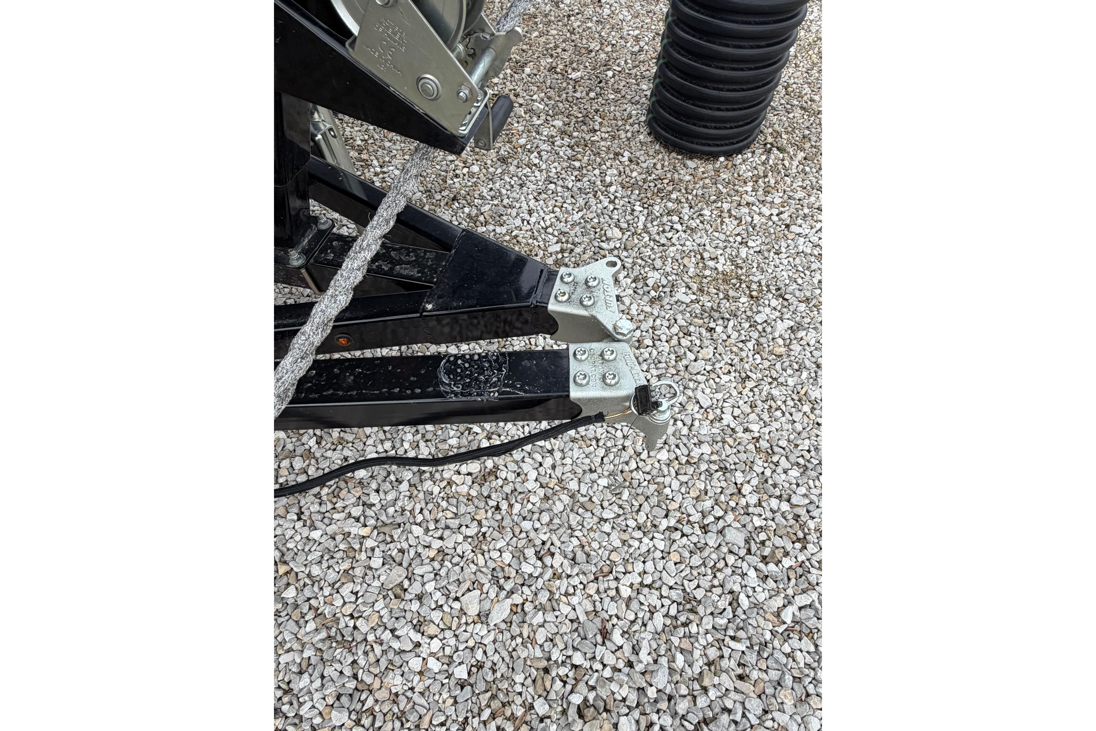 Close-up of 2023 SeaArk 180 RX trailer hitch on gravel surface.