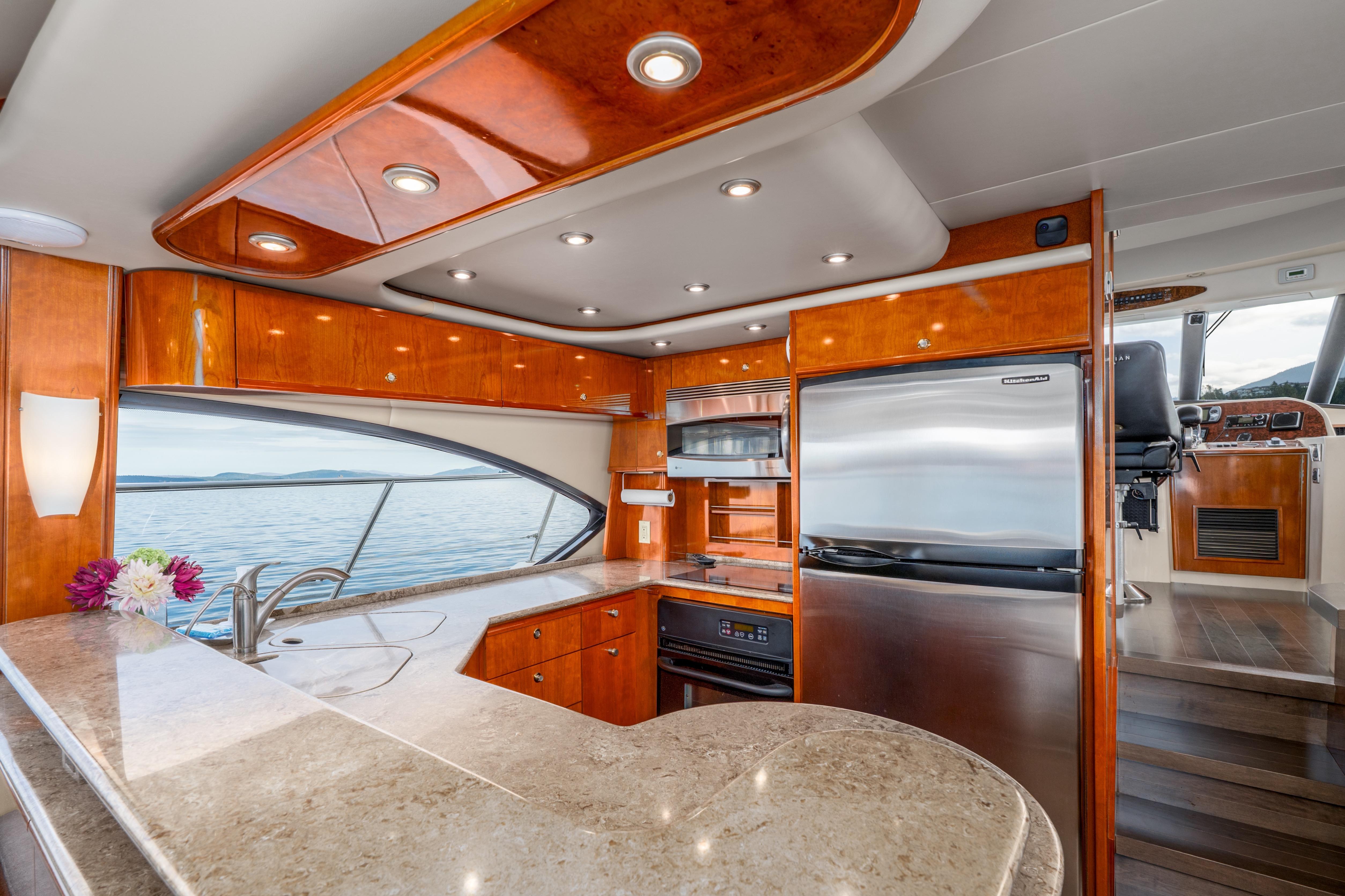 Luxurious 2007 Meridian 580 Pilothouse yacht kitchen with modern appliances and elegant wood finishes.