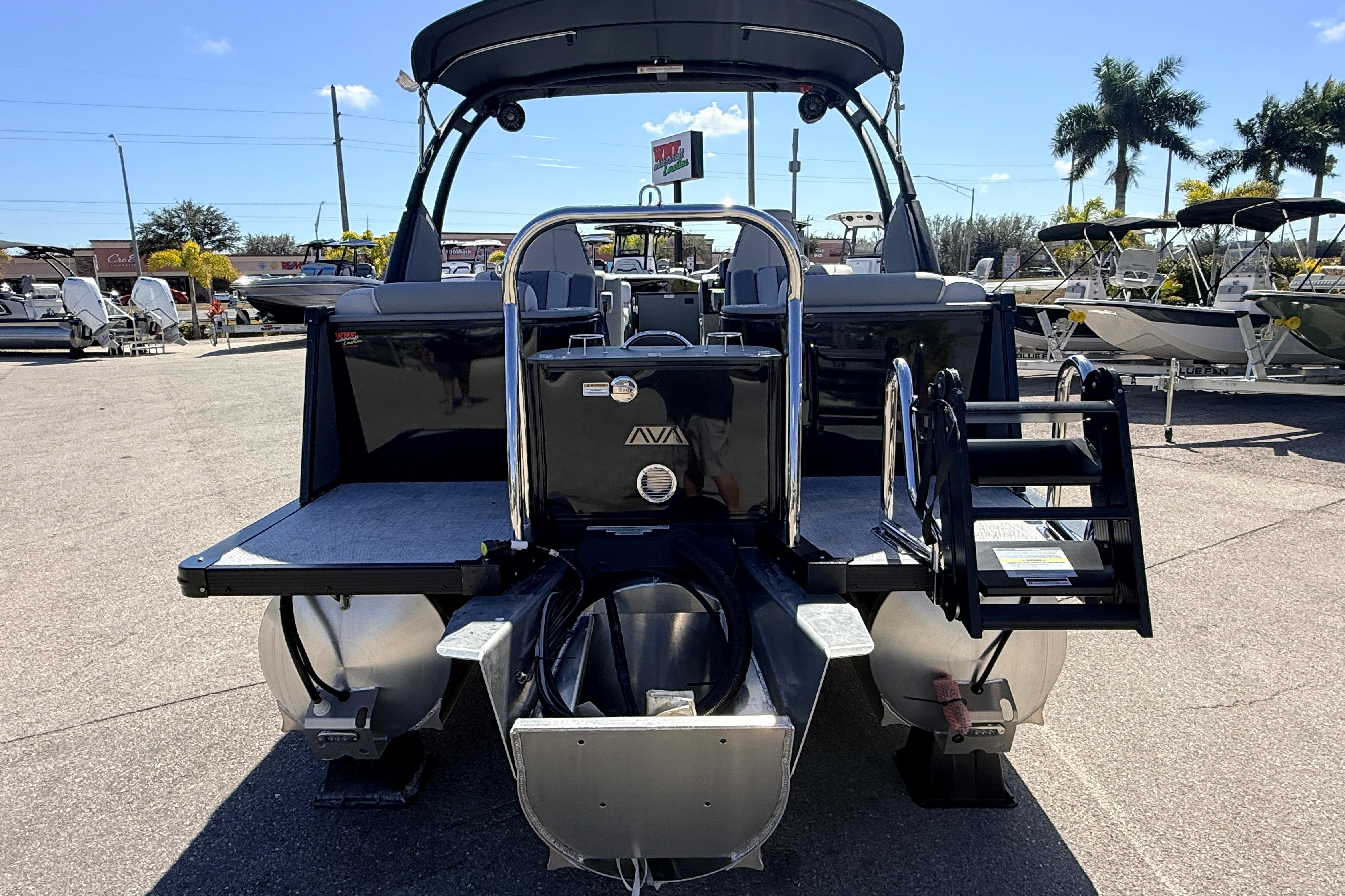 2026 Avalon 2385 Catalina Quad Lounger Tri Toon, rear view at a sunny marina.