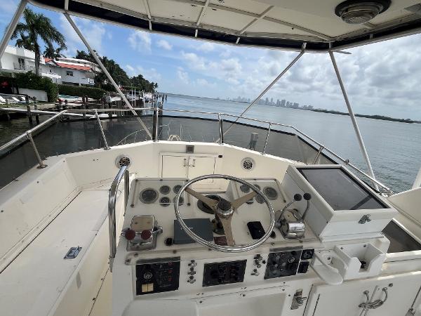 1985 Hatteras 45 Convertible yacht helm with ocean view and city skyline.
