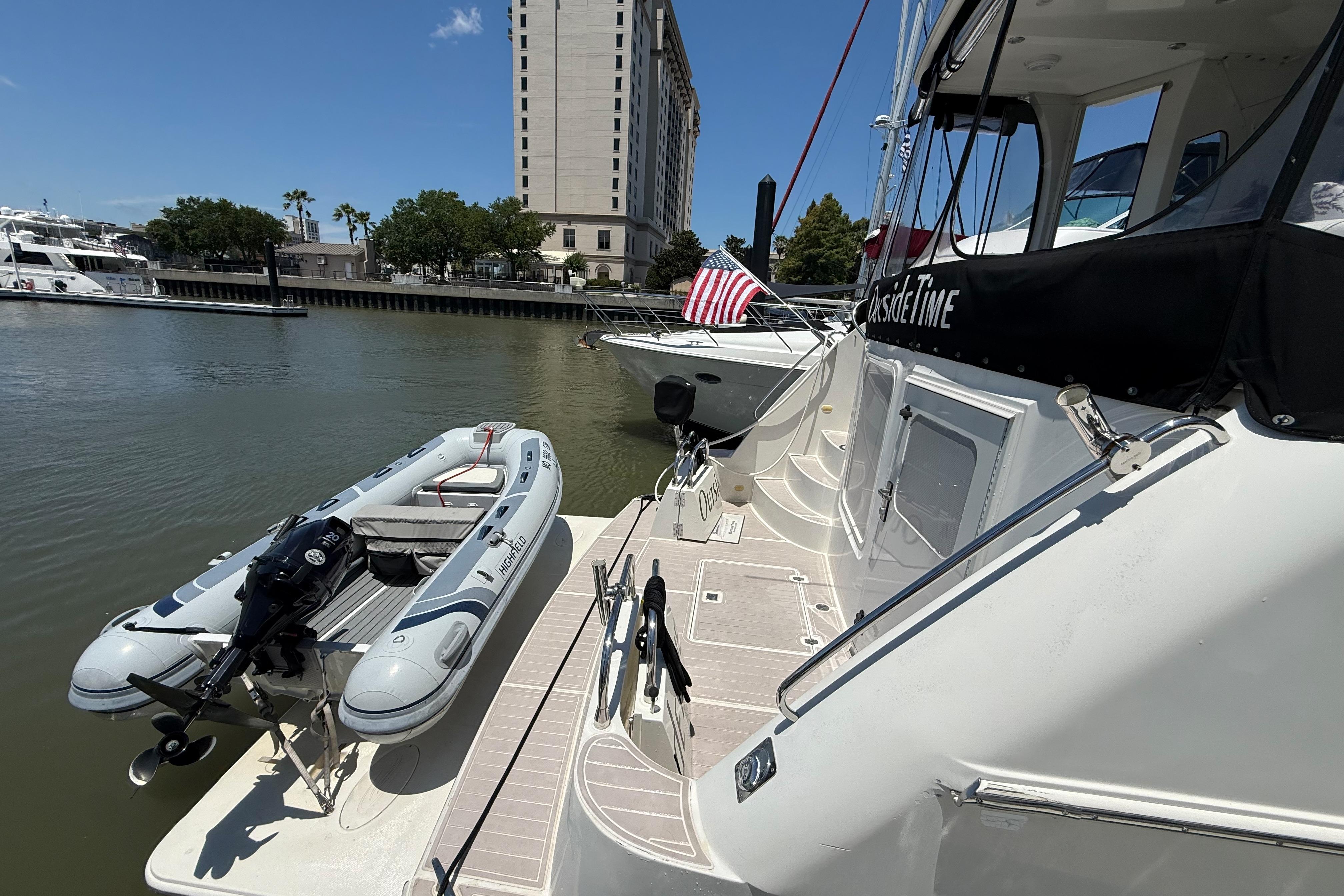 2006 Carver 43 Motor Yacht docked with inflatable boat and American flag.
