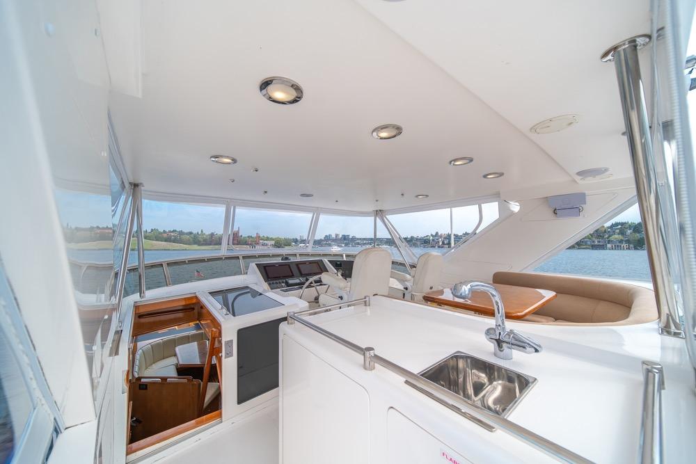 Luxurious 2005 Ocean Alexander 64 Motoryacht interior with helm, seating, and sink.