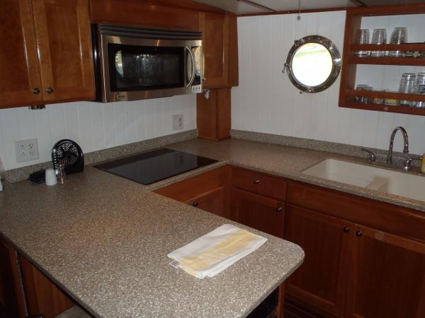 Modern kitchen in 2025 Great Harbour N40 yacht with microwave, sink, and porthole window.