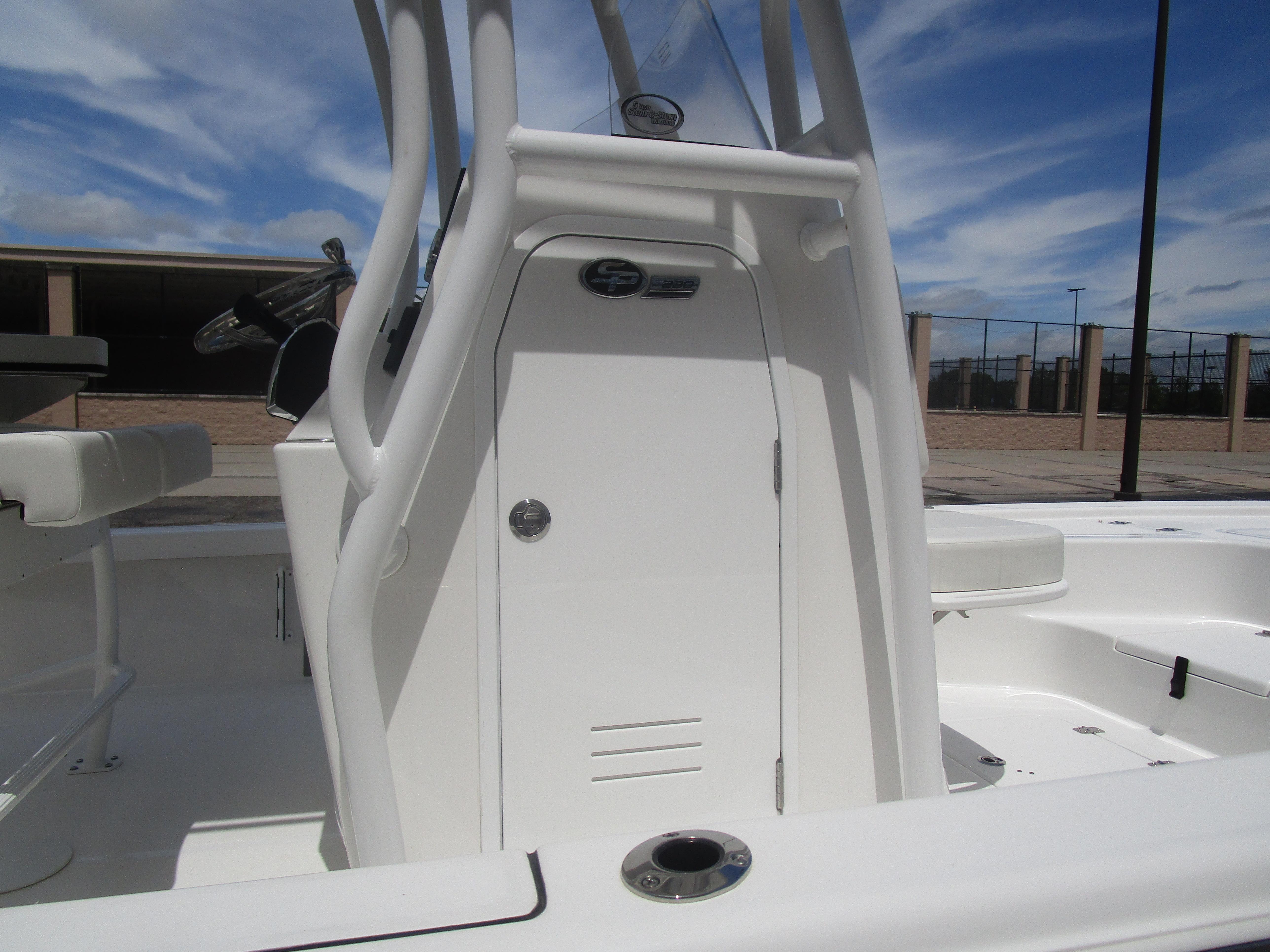 2025 Sea Pro 230 DLX BAY boat interior with console and seating, under a clear blue sky.