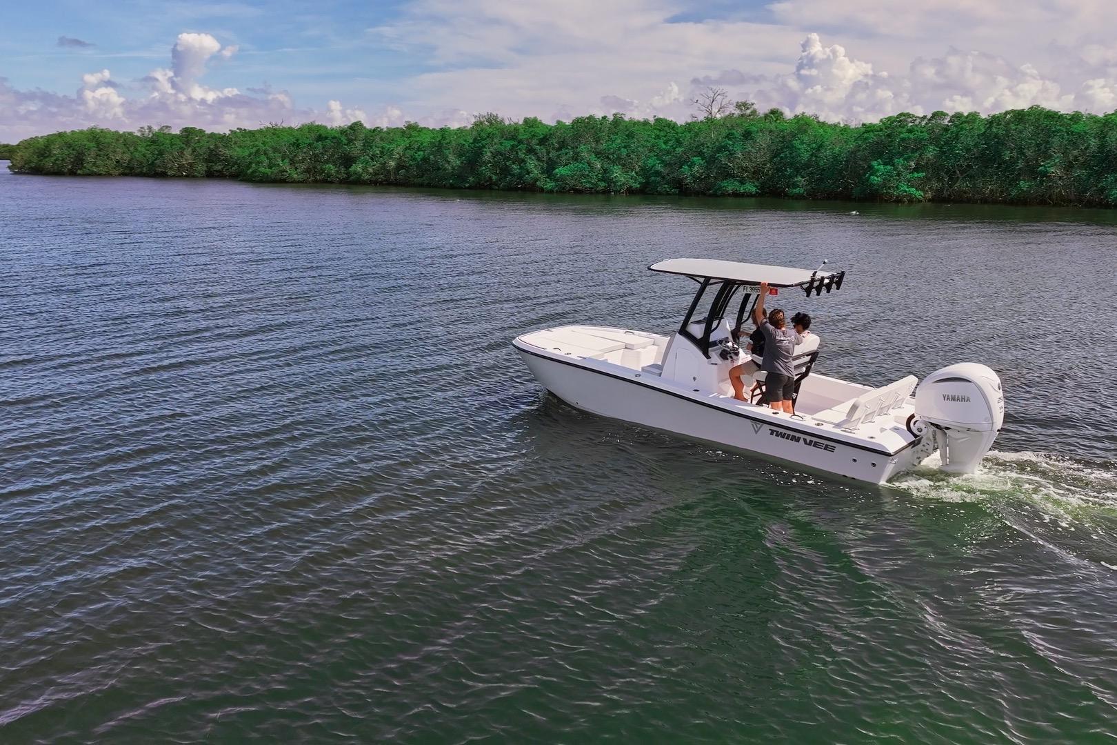 2026 Twin Vee 22 BayCat cruising on a serene river with lush green shoreline.