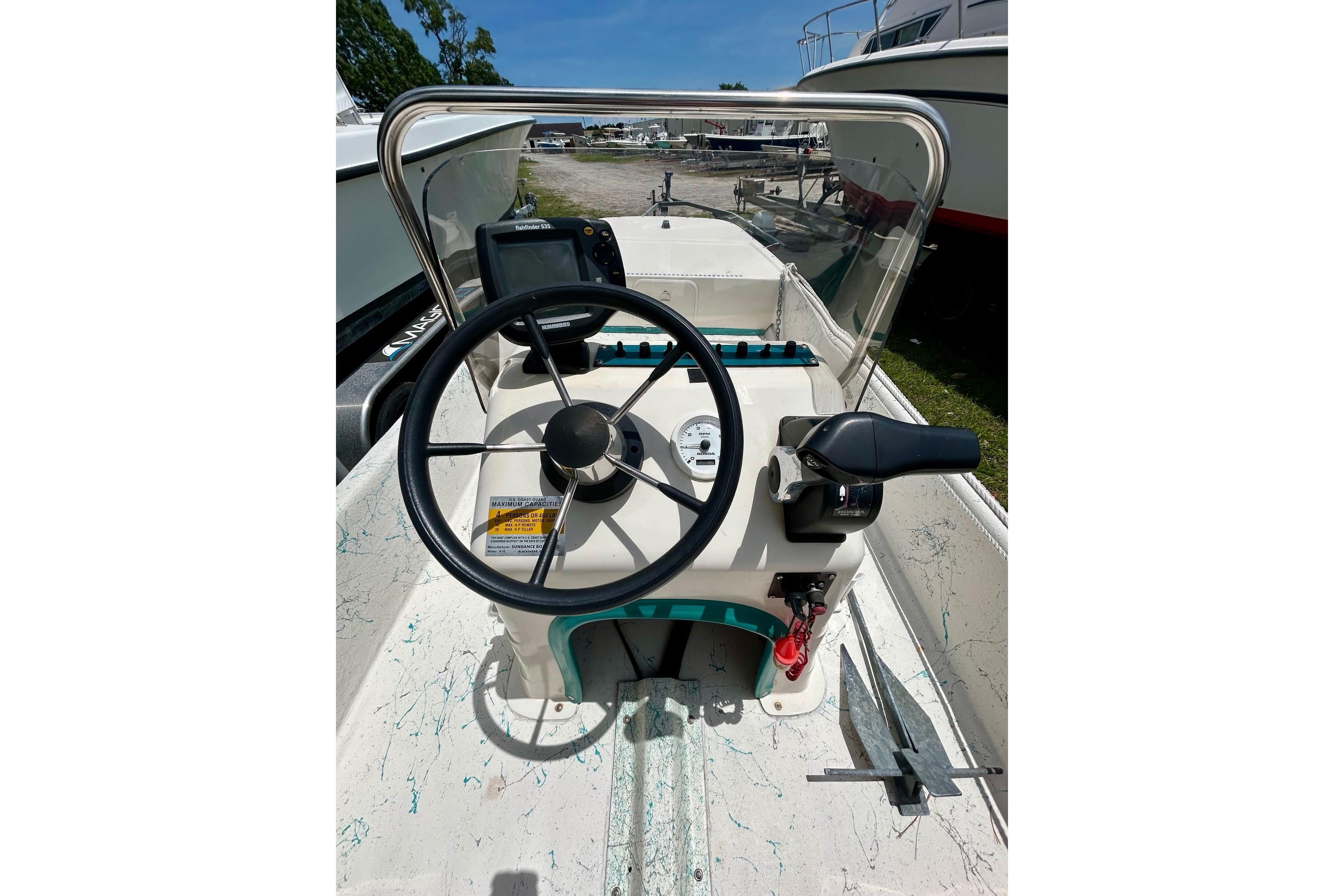 Steering console of a 2002 Sundance K16CC boat with navigation equipment.