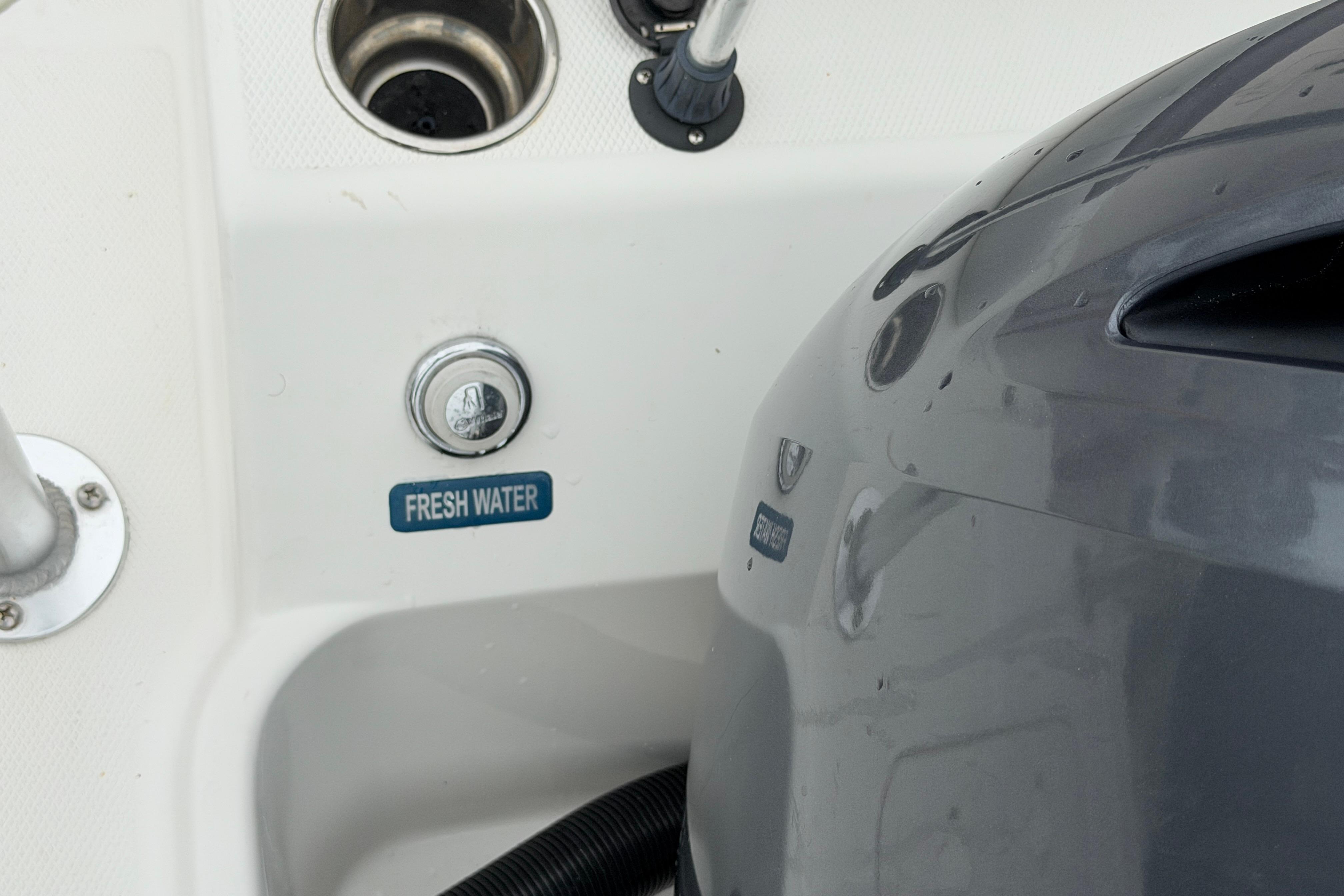 2019 World Cat 230 DC boat detail with fresh water access and engine cover.