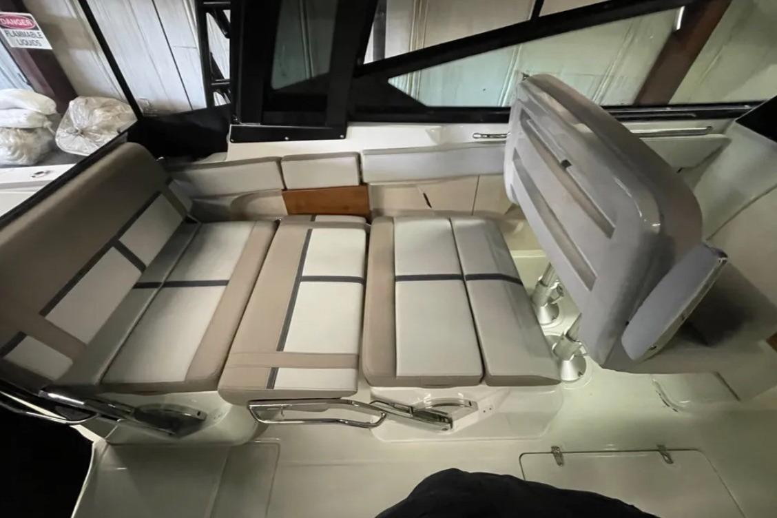 2025 Boston Whaler 330 Vantage interior seating with beige cushions and adjustable backrest.