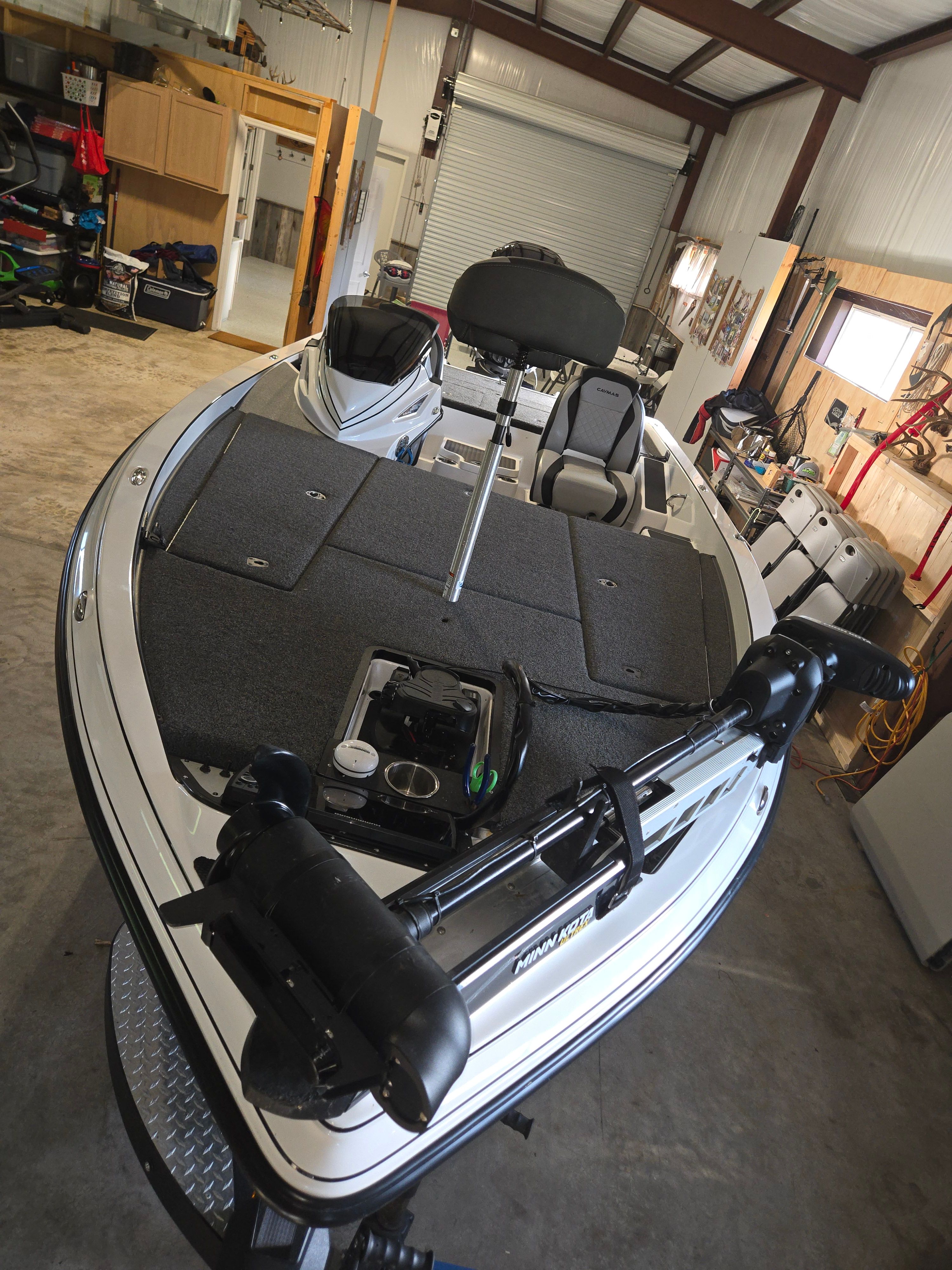 A 2022 Caymas CX 19 boat in a garage, featuring a gray deck and black seat.