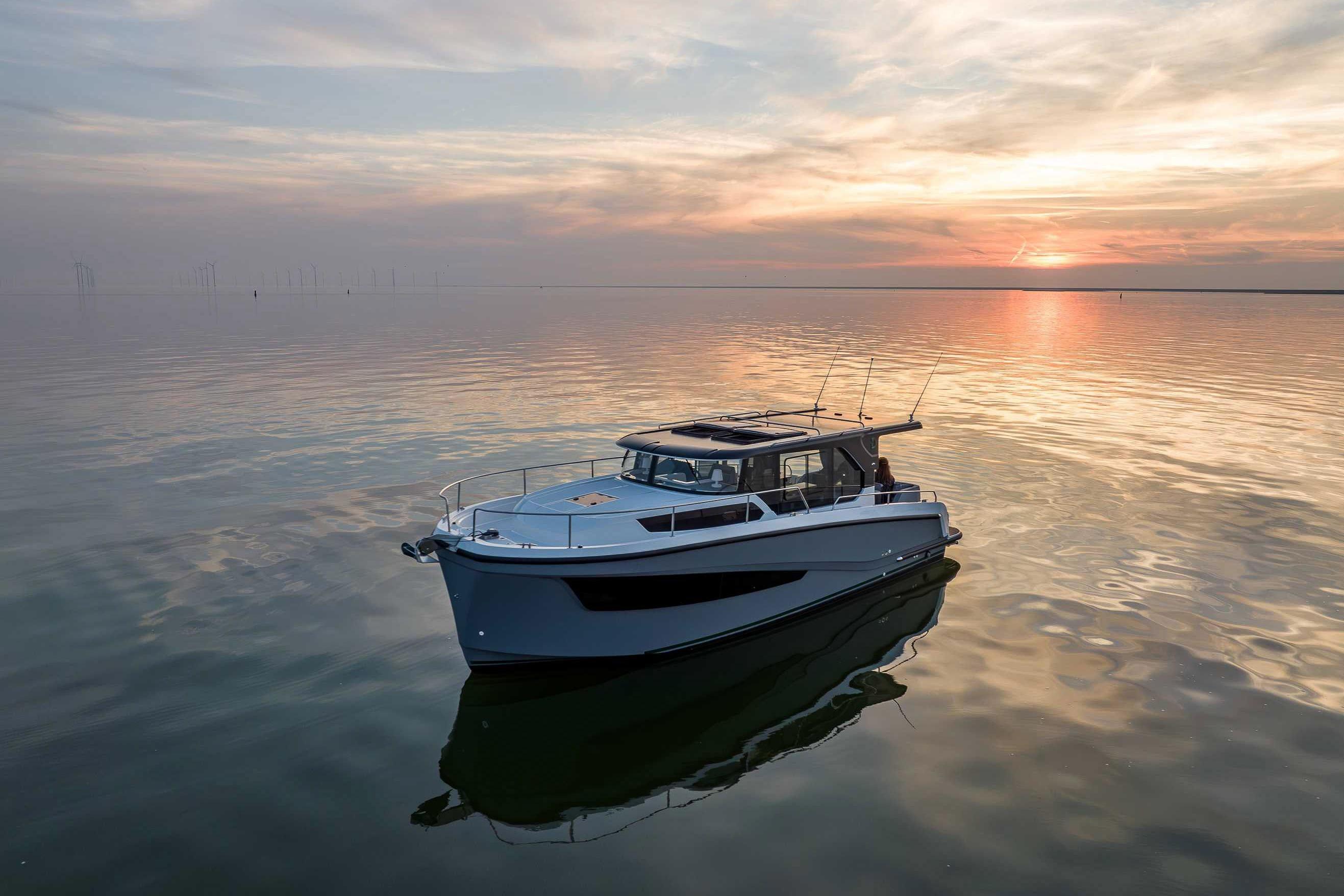 2026 Delphia D10 Sedan boat on calm water at sunset.