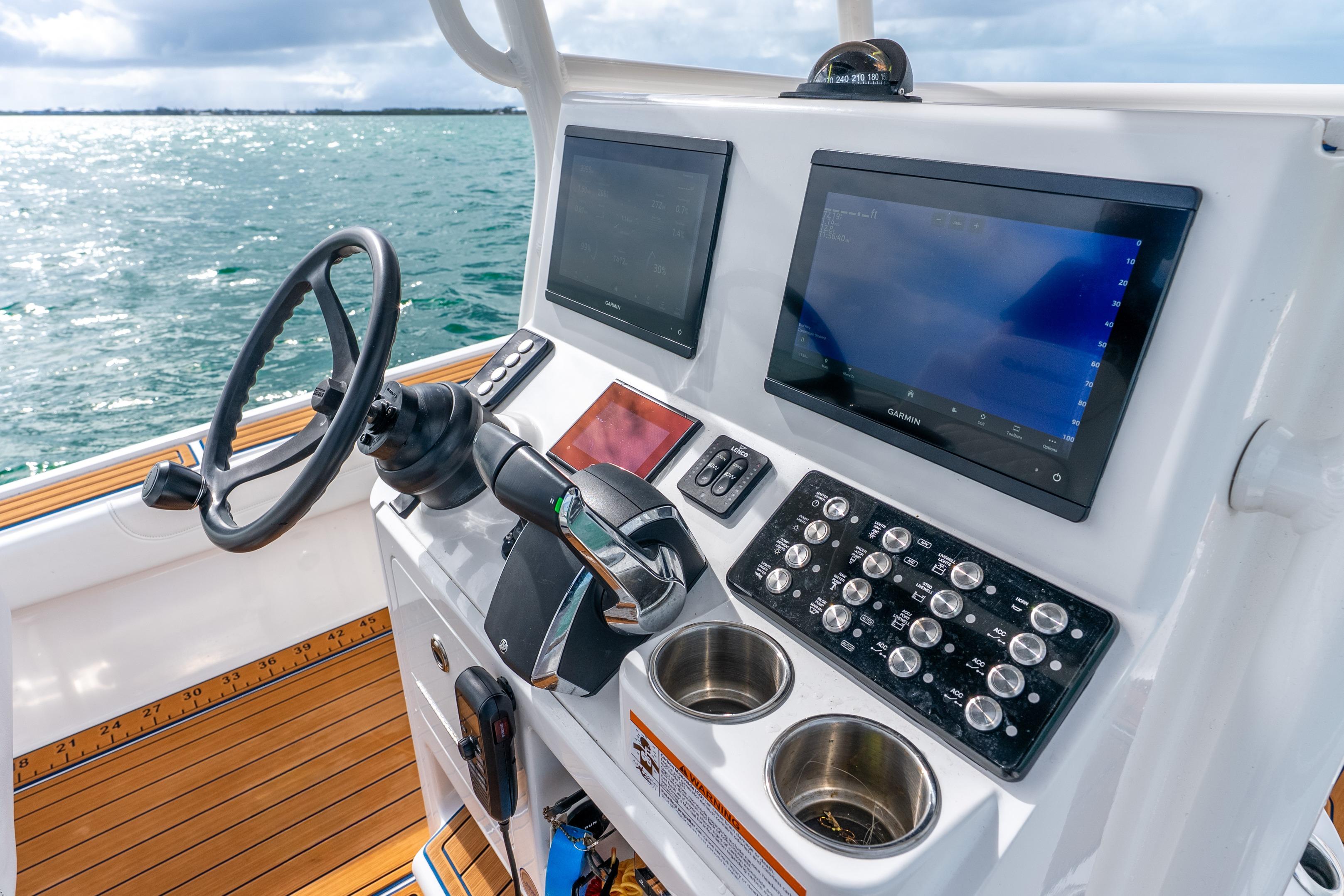 2024 Caymas 281 HB boat dashboard with steering wheel and navigation screens.