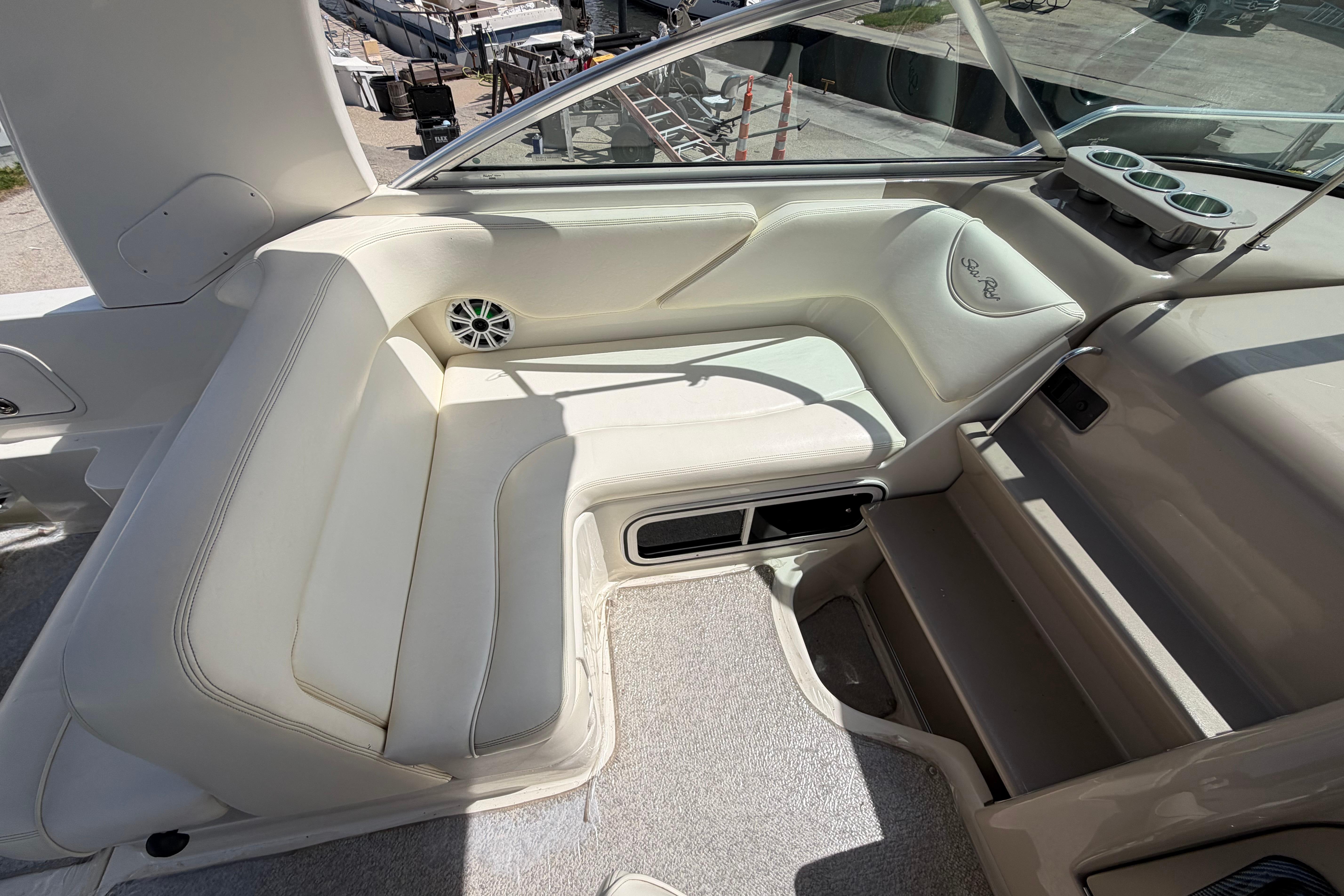 2004 Sea Ray Sundancer 260 interior with white seating and cup holders.