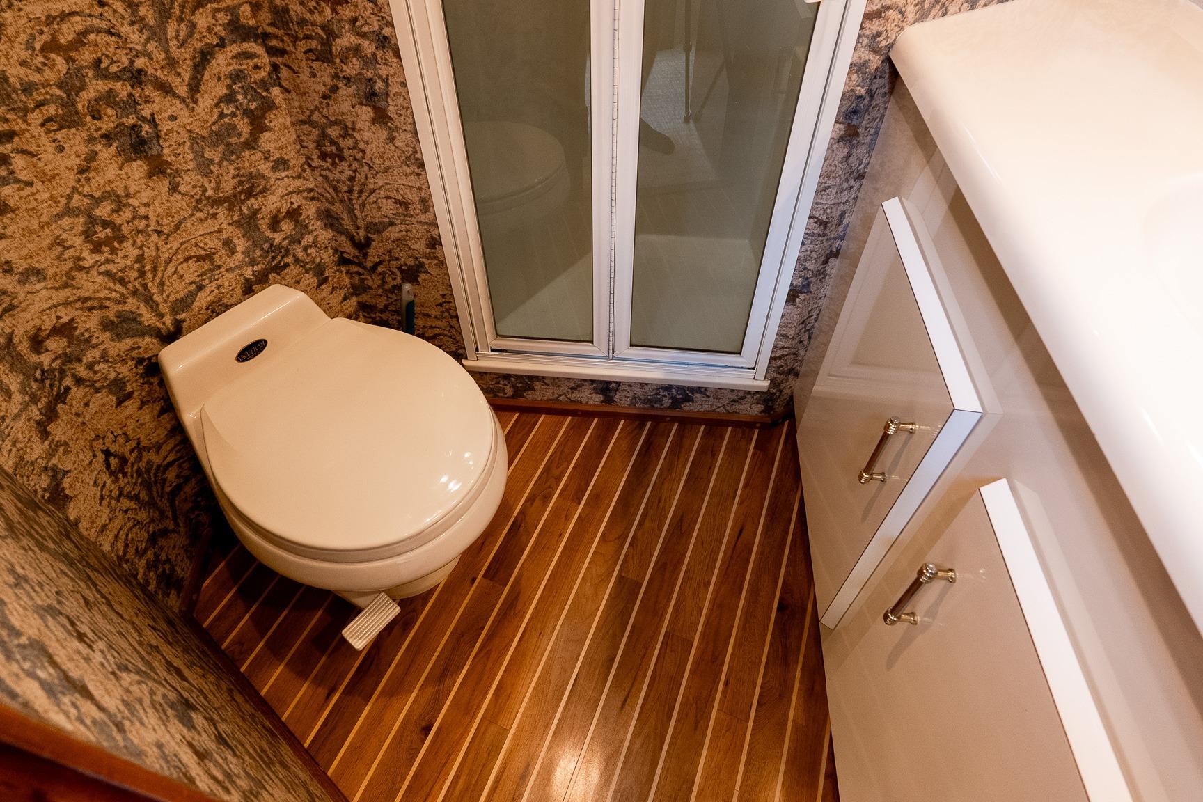 Luxurious bathroom in 2000 Viking 50' Convertible yacht with elegant wood flooring.