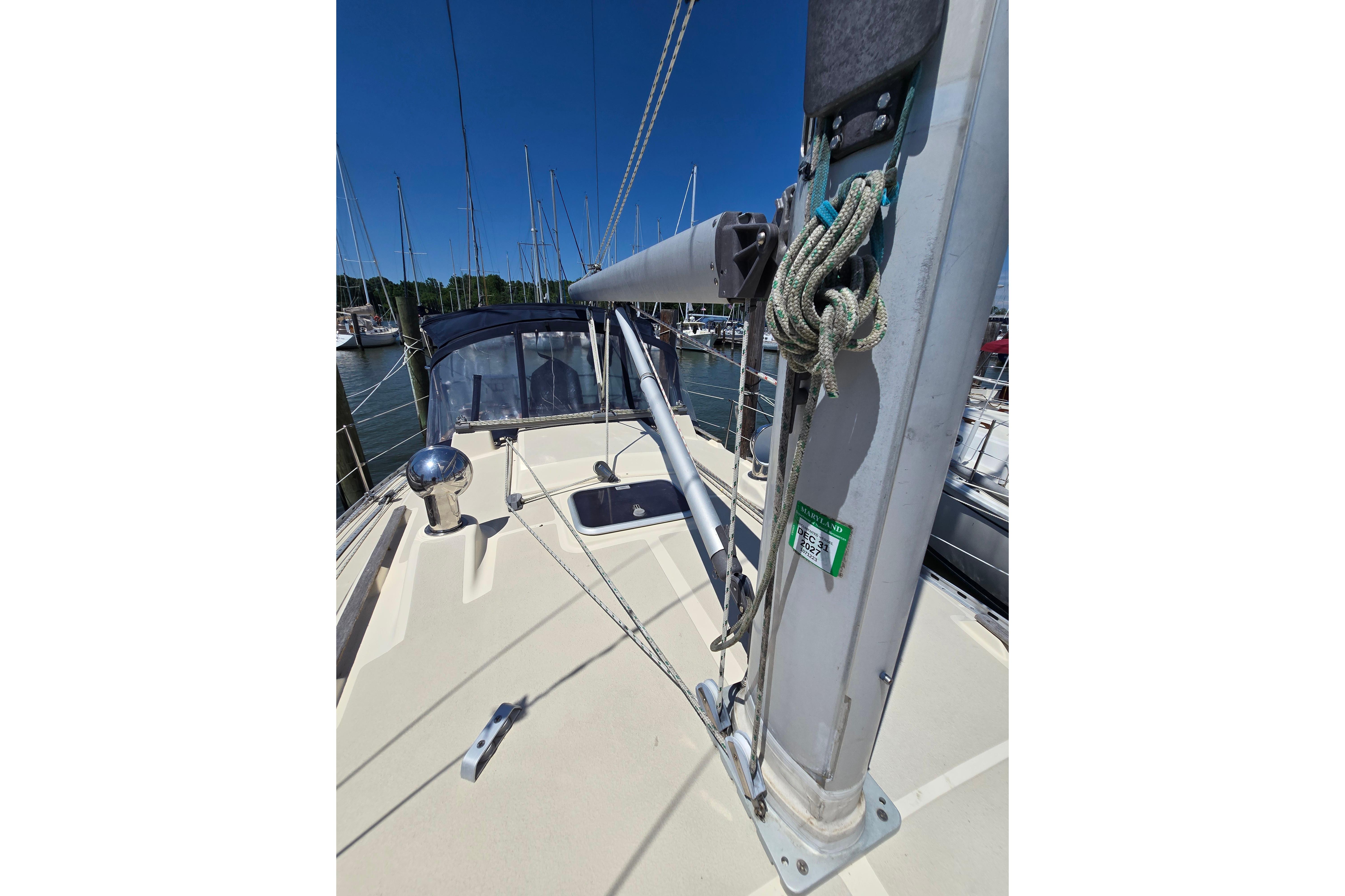 Sailboat deck view of a 1993 Caliber 35, featuring rigging and marina backdrop.