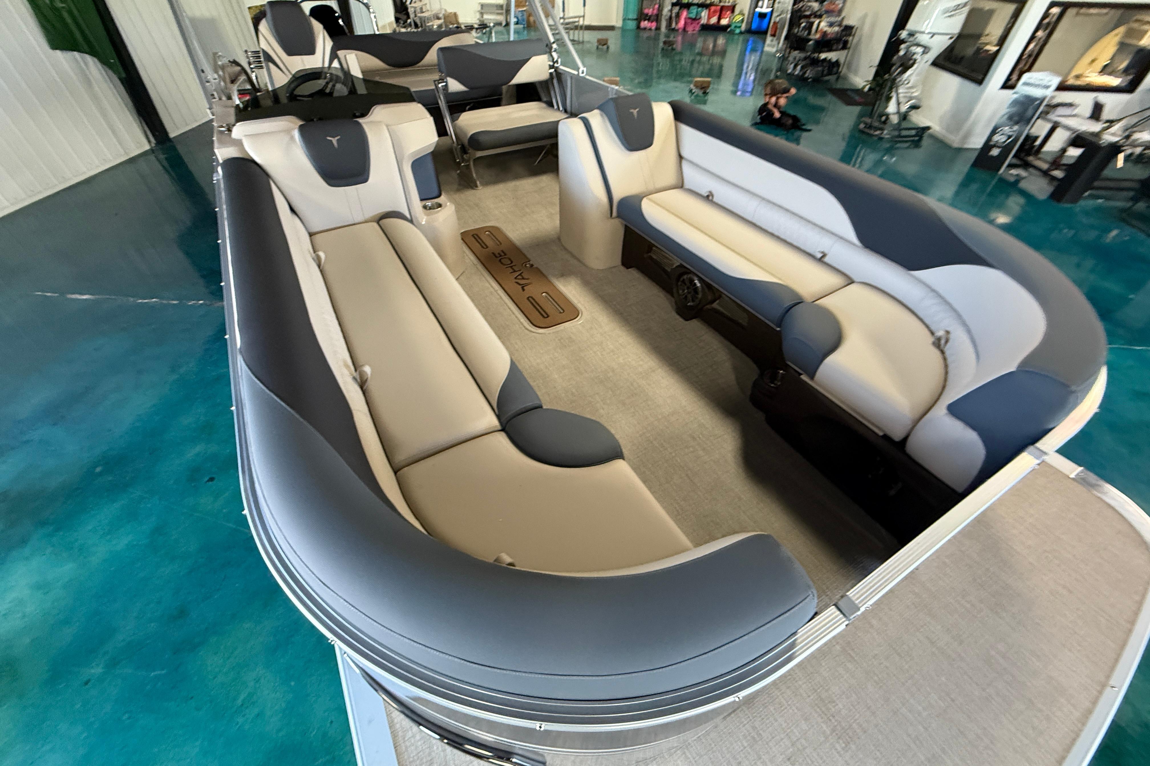 2026 Tahoe Pontoon LTZ Entertainer with luxurious seating in showroom.
