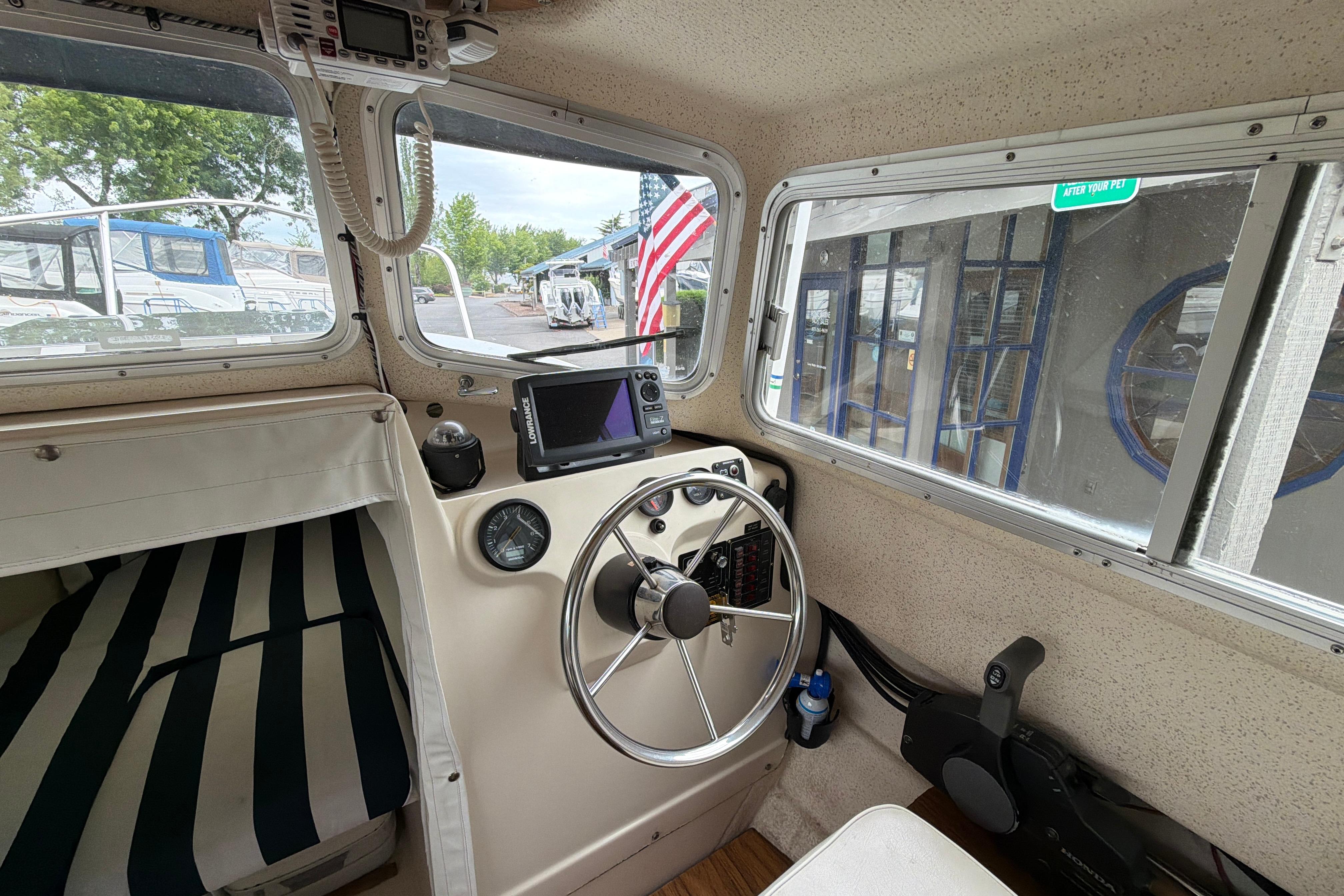 Interior of a 1989 C-Dory 22' Angler boat with steering wheel and navigation equipment.